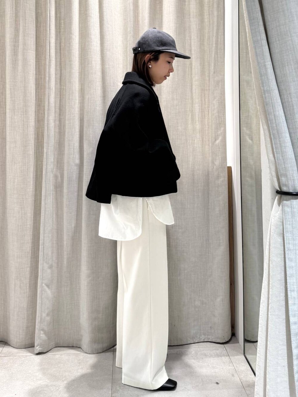 ホワイト系のその他パンツ、ホワイト系のシャツ/ブラウス、ブラック系のピーコートを着用したレディースの冬コーディネートの3枚目の写真