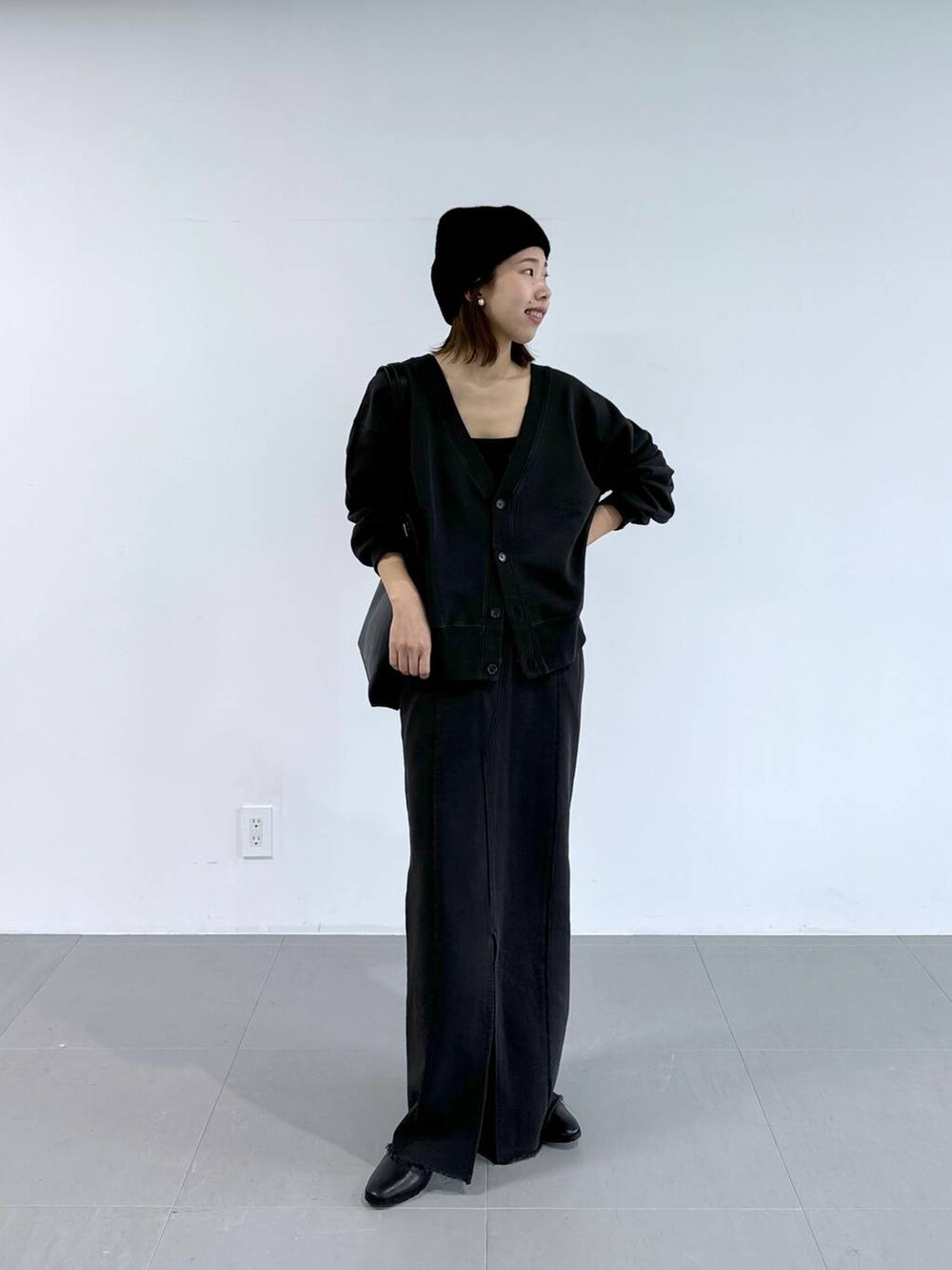 ブラック系のキャミソール、グレー系のスカート、グレー系のカーディガン/ボレロを着用したレディースの冬コーディネートの2枚目の写真