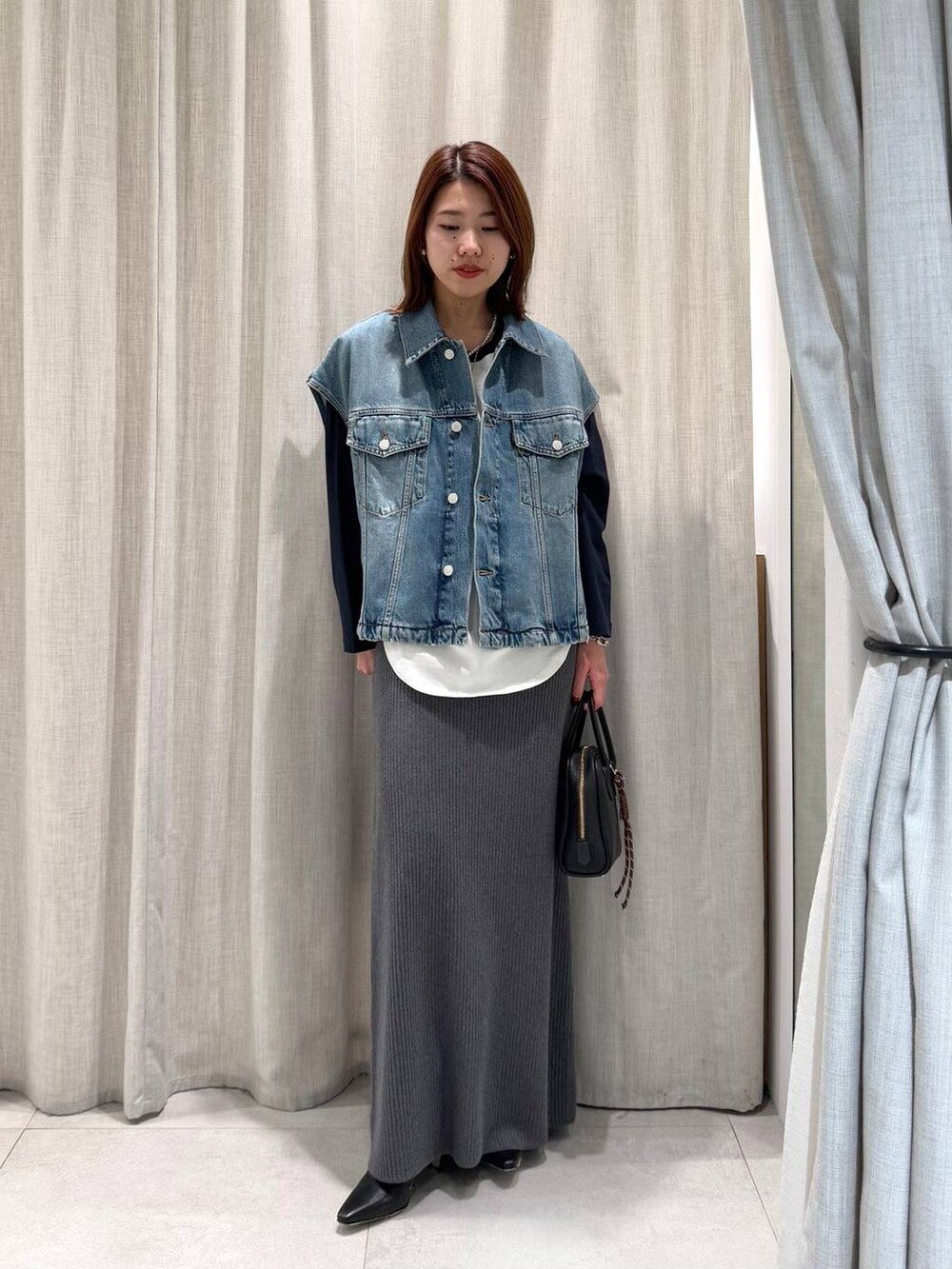 ブルー系のTシャツ/カットソー、グレー系のスカート、ブラック系のブーツを着用したレディースの冬コーディネートの3枚目の写真