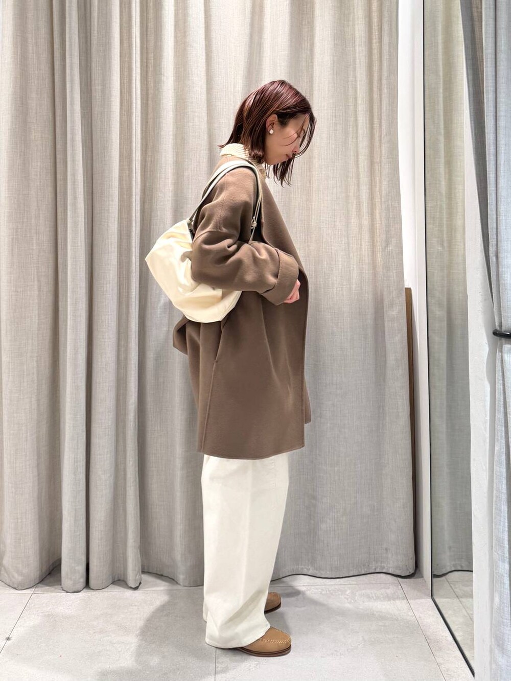 ベージュ系のショルダーバッグ、グリーン系のピーコート、ホワイト系のその他パンツを着用したレディースの冬コーディネートの6枚目の写真