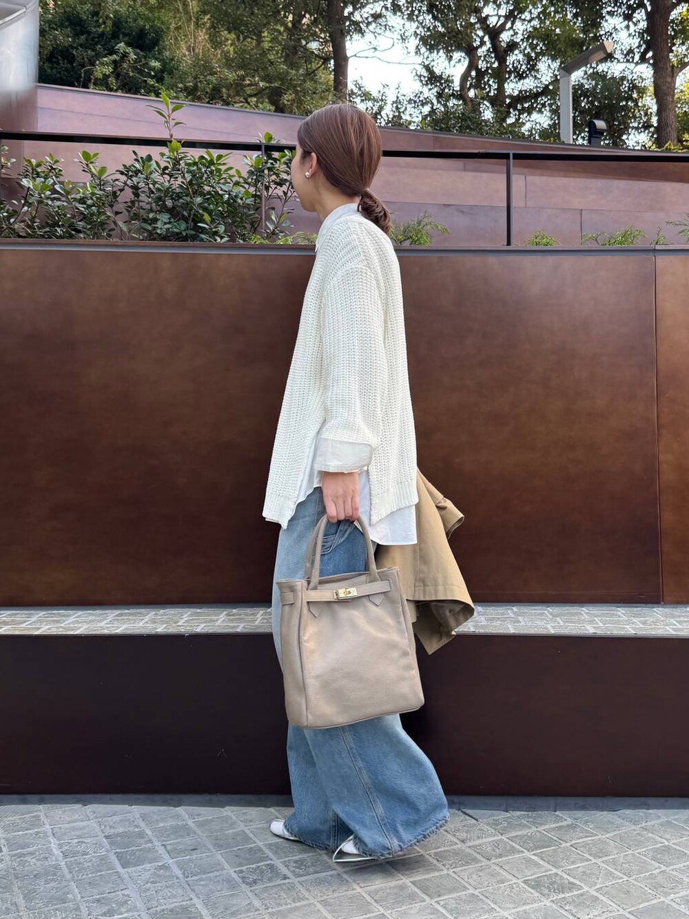 ブルー系のデニムパンツ、ホワイト系のニット/セーター、ホワイト系のシャツ/ブラウスを着用したレディースの春コーディネートの6枚目の写真