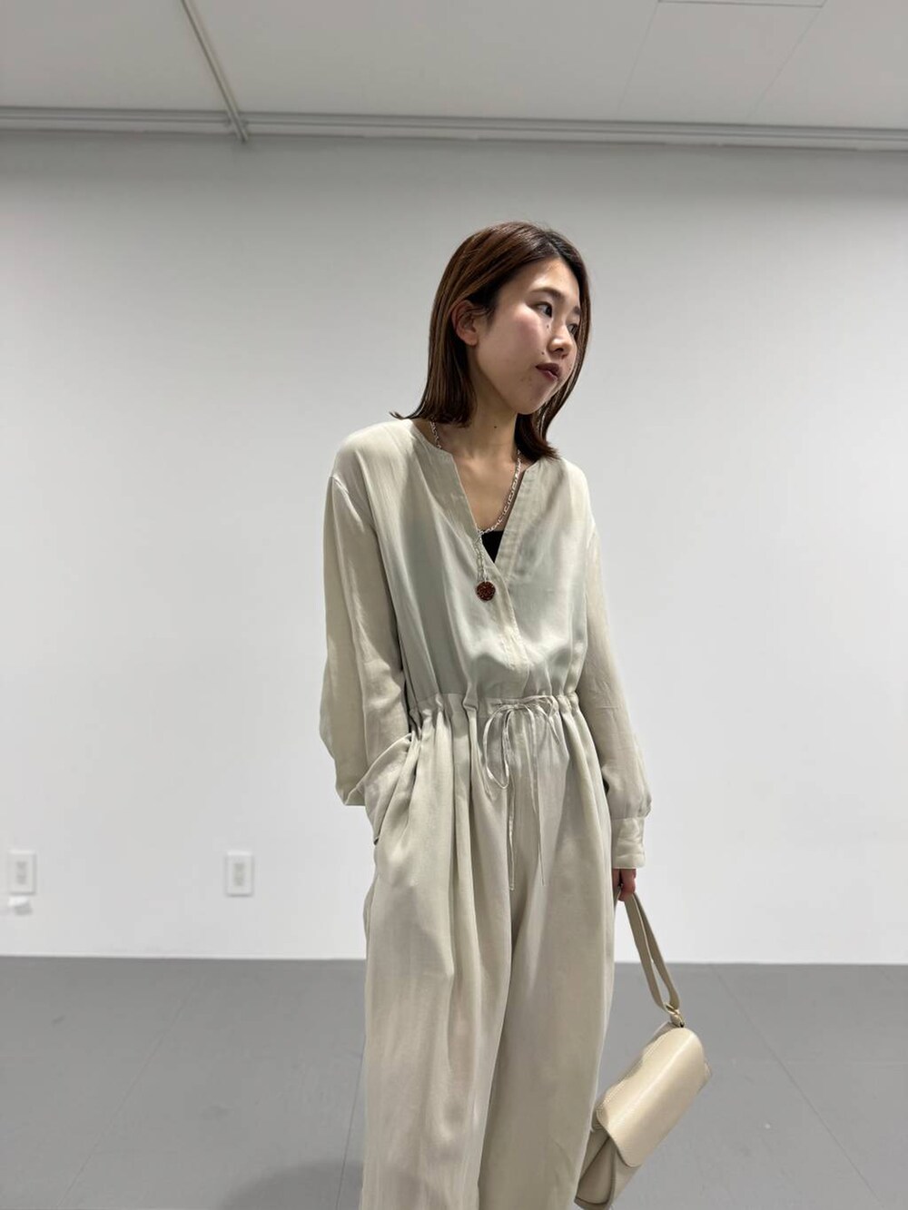 ホワイト系のショルダーバッグ、ブラック系のキャミソール、ベージュ系のつなぎ/オールインワンを着用したレディースの春コーディネートの6枚目の写真