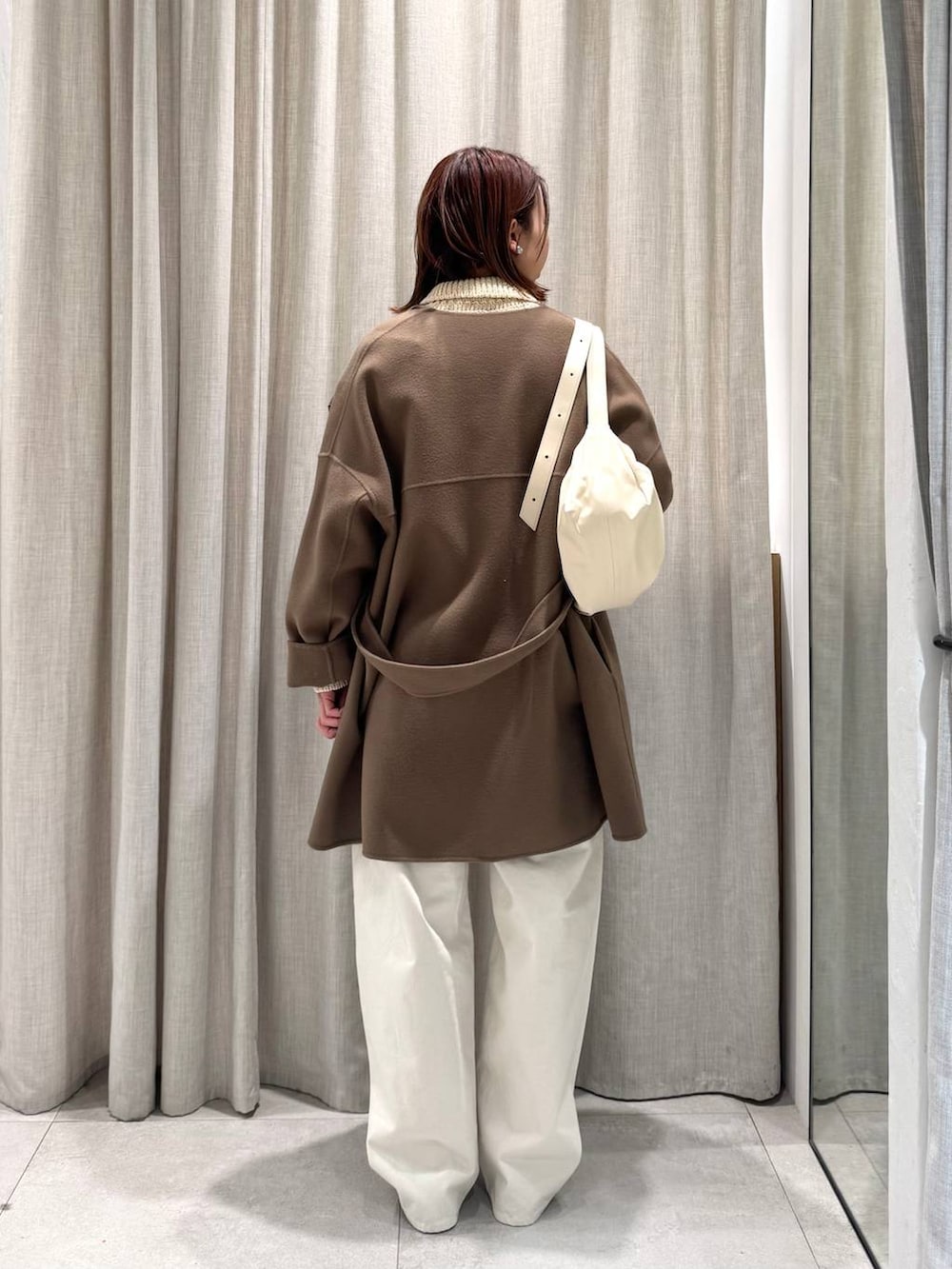 ベージュ系のショルダーバッグ、グリーン系のピーコート、ホワイト系のその他パンツを着用したレディースの冬コーディネートの7枚目の写真