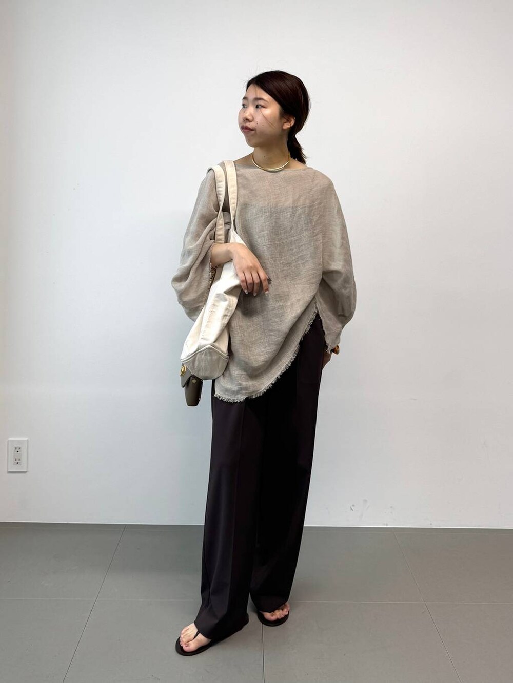 ブラウン系のサンダル、ホワイト系のトートバッグ、ベージュ系のその他トップスを着用したレディースの夏コーディネートの2枚目の写真