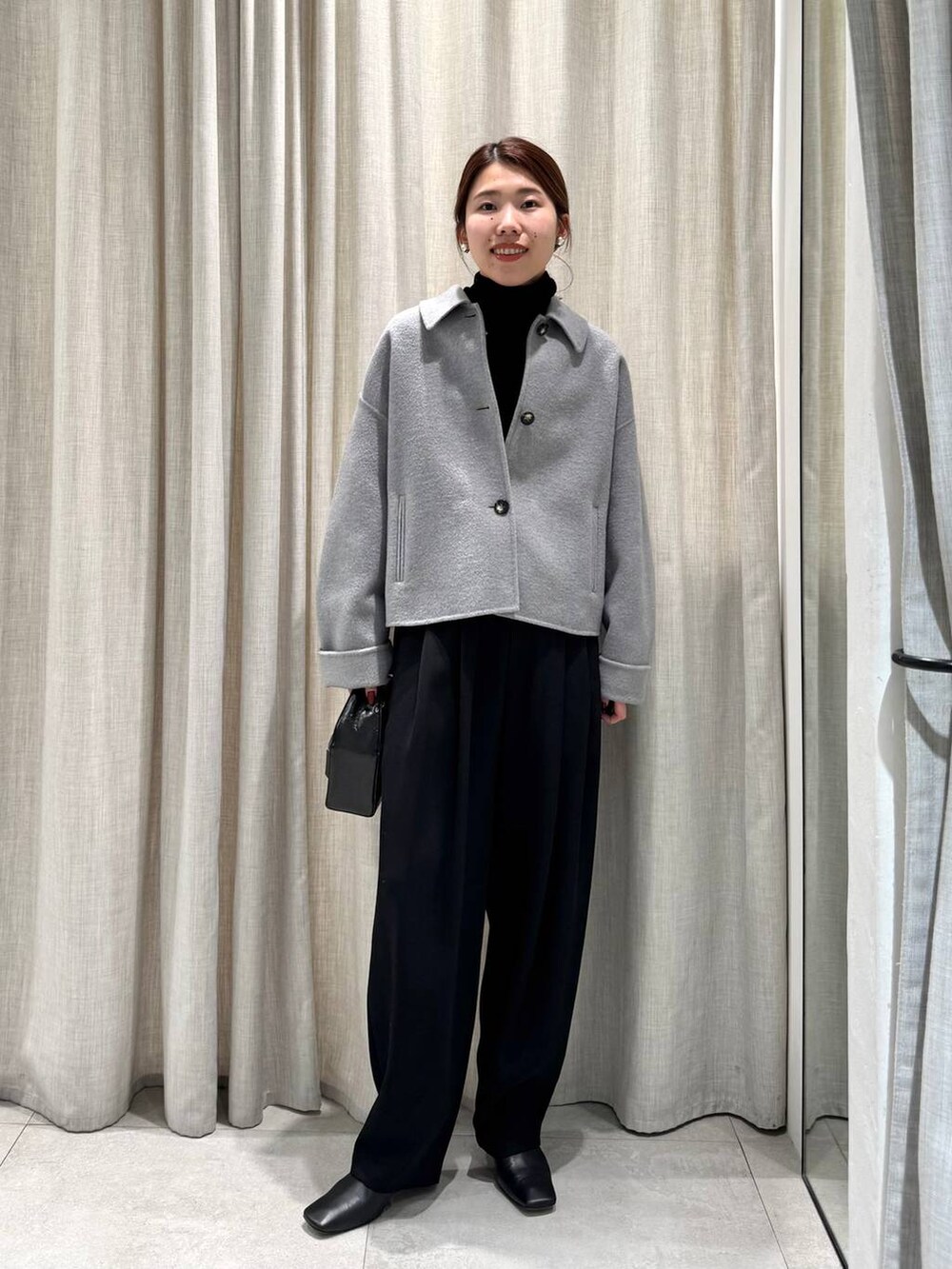 ブラック系のその他パンツ、ブラック系のニット/セーター、グレー系のその他アウターを着用したレディースの冬コーディネートの2枚目の写真