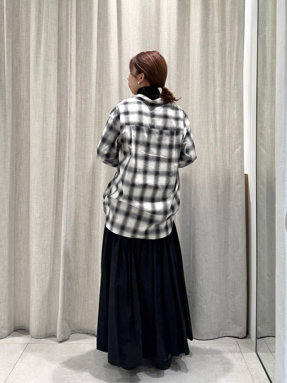 ブラック系のニット/セーター、ブラック系のシャツ/ブラウス、グリーン系のピーコートを着用したレディースの冬コーディネートの9枚目の写真