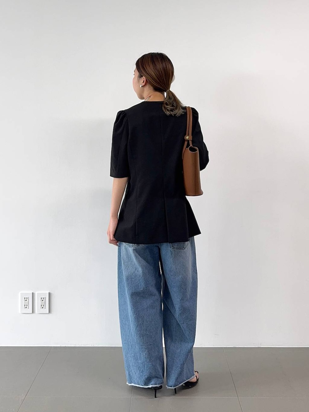 ブラック系のサンダル、ブルー系のデニムパンツ、イエロー系のハンドバッグを着用したレディースの春コーディネートの6枚目の写真