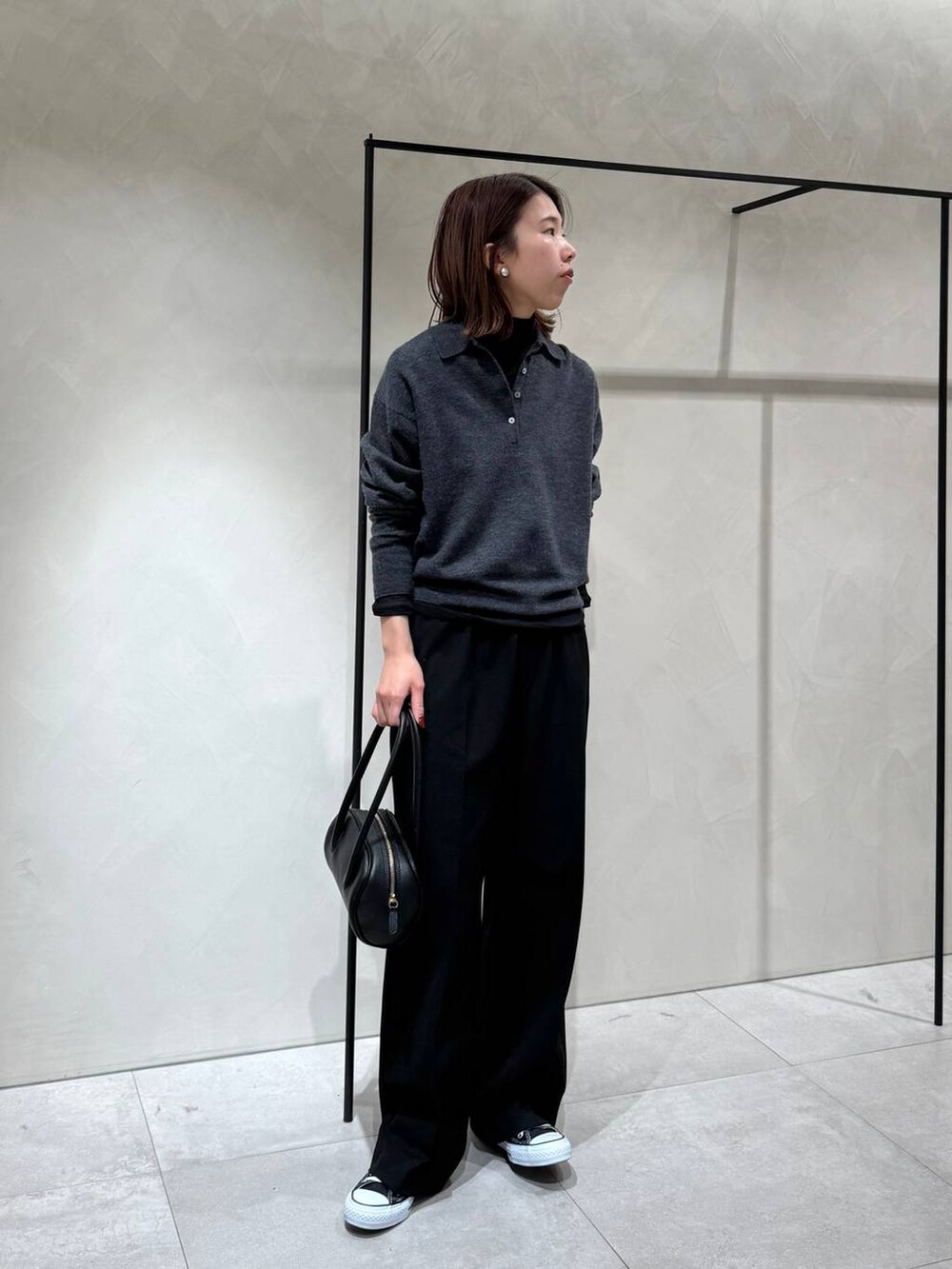 ブラック系のスニーカー、ブラック系のTシャツ/カットソー、グレー系のニット/セーターを着用したレディースの冬コーディネートの2枚目の写真