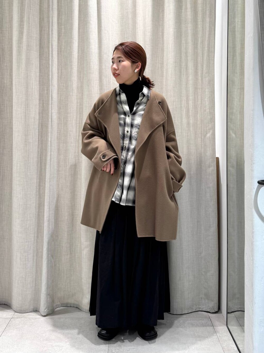 ブラック系のニット/セーター、ブラック系のシャツ/ブラウス、グリーン系のピーコートを着用したレディースの冬コーディネートの3枚目の写真