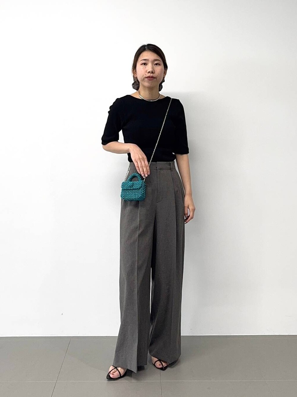 ブラック系のサンダル、ブラック系のTシャツ/カットソー、グレー系のその他パンツを着用したレディースの春コーディネートの4枚目の写真