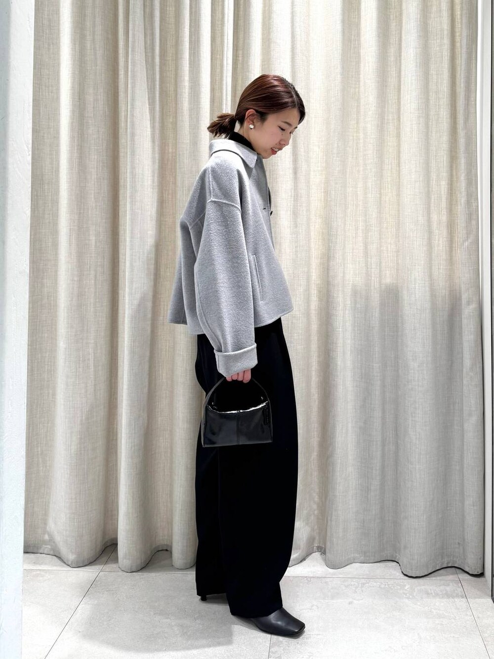 ブラック系のその他パンツ、ブラック系のニット/セーター、グレー系のその他アウターを着用したレディースの冬コーディネートの7枚目の写真