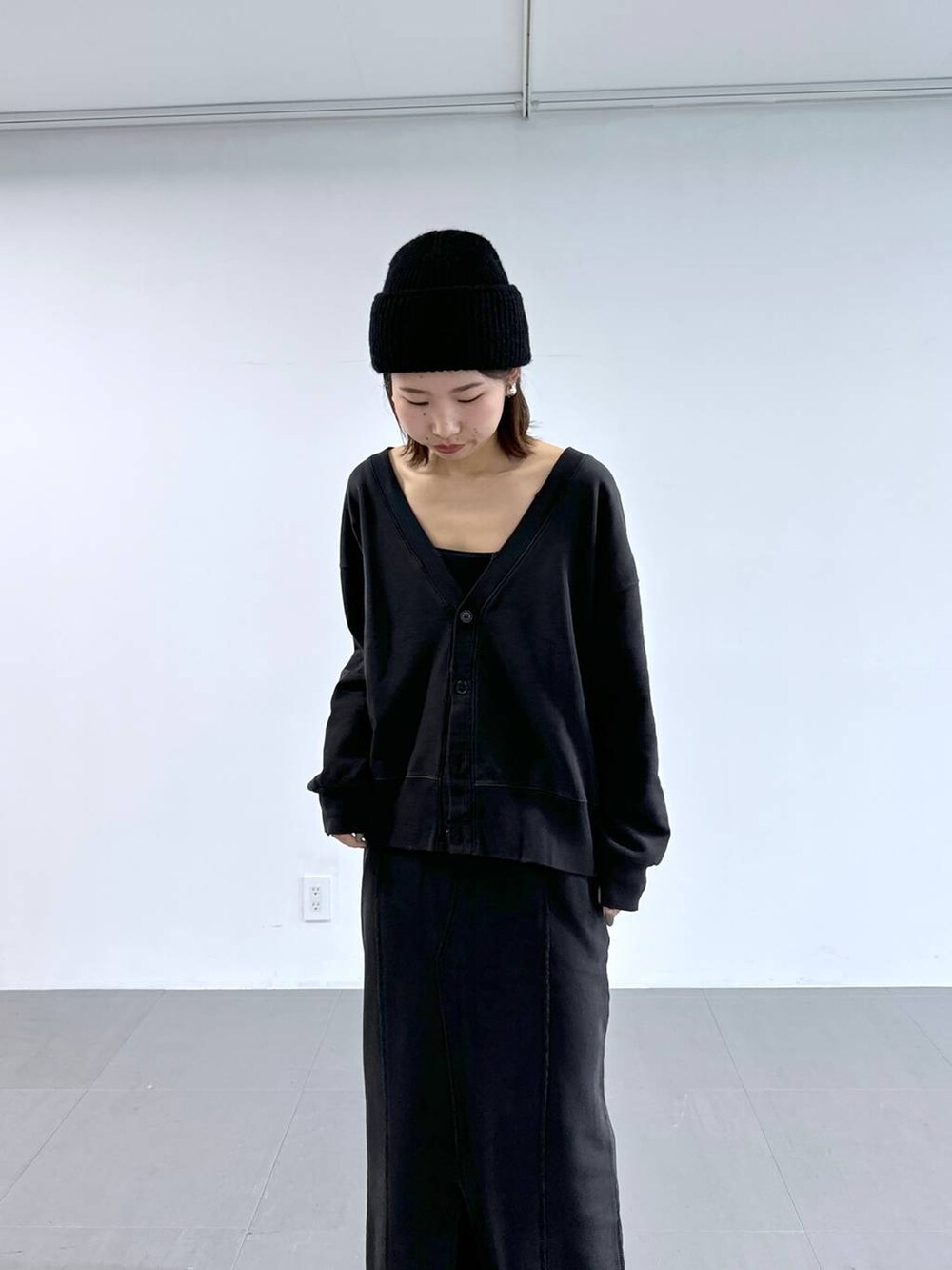 ブラック系のキャミソール、グレー系のスカート、グレー系のカーディガン/ボレロを着用したレディースの冬コーディネートの7枚目の写真