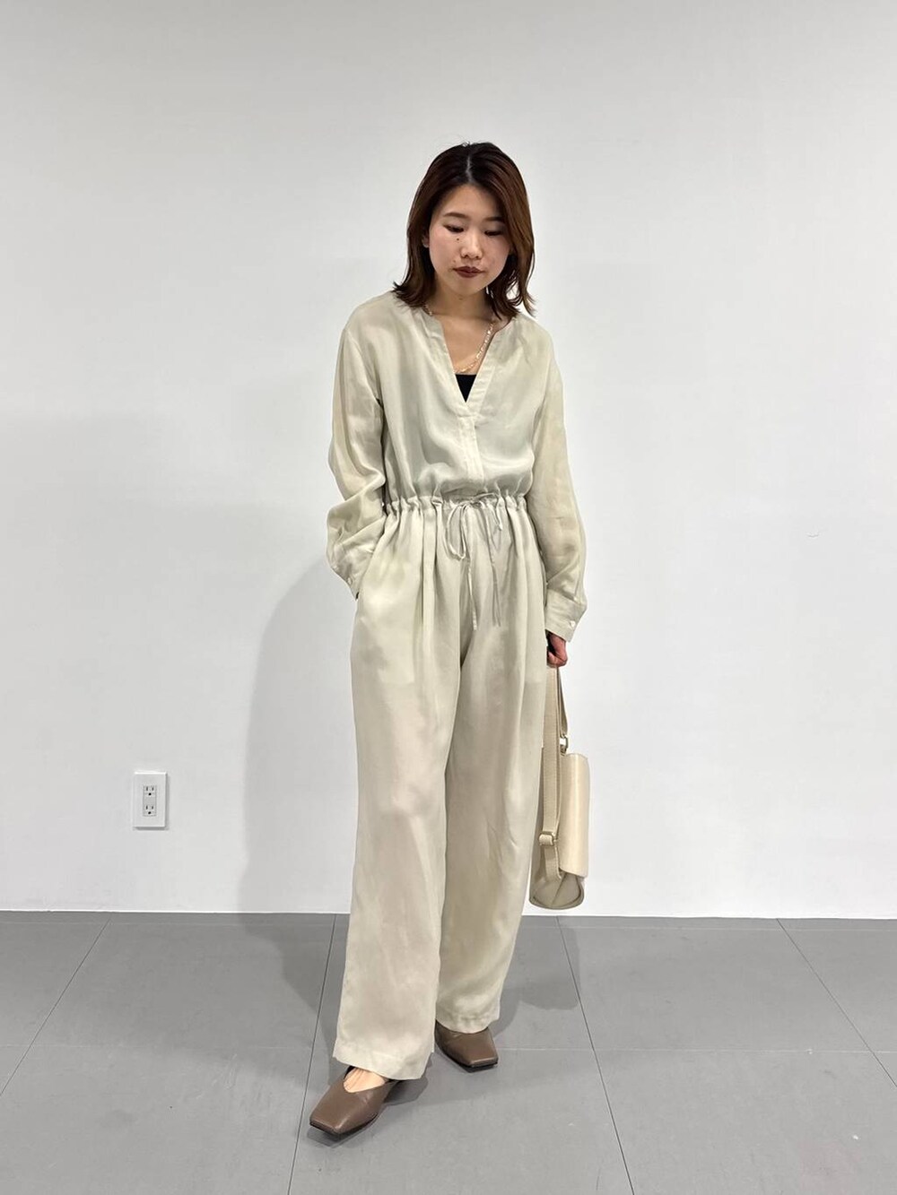 ホワイト系のショルダーバッグ、ブラック系のキャミソール、ベージュ系のつなぎ/オールインワンを着用したレディースの春コーディネートの2枚目の写真