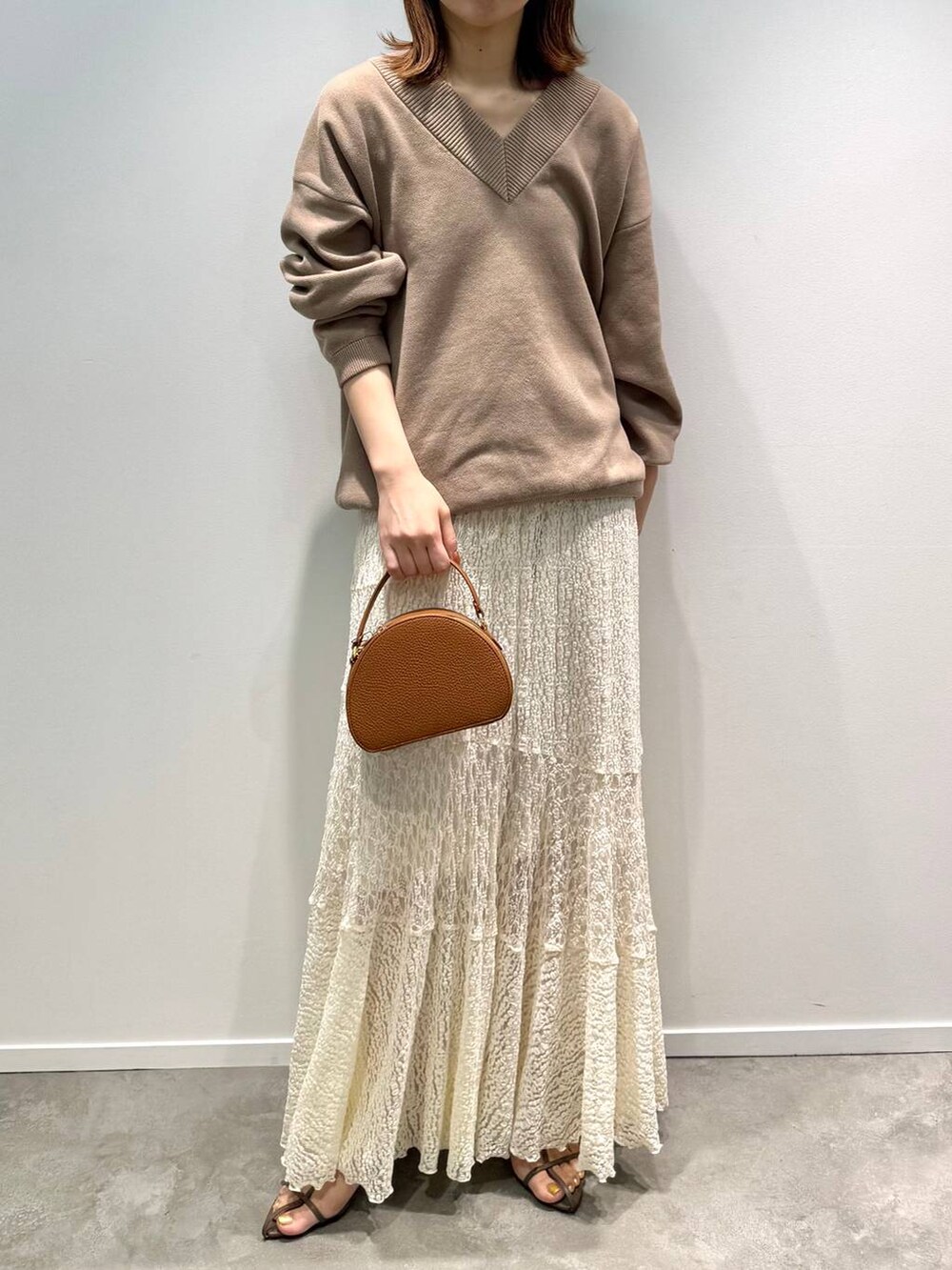 ベージュ系のサンダル、ホワイト系のスカート、イエロー系のハンドバッグを着用したレディースの夏コーディネートの5枚目の写真