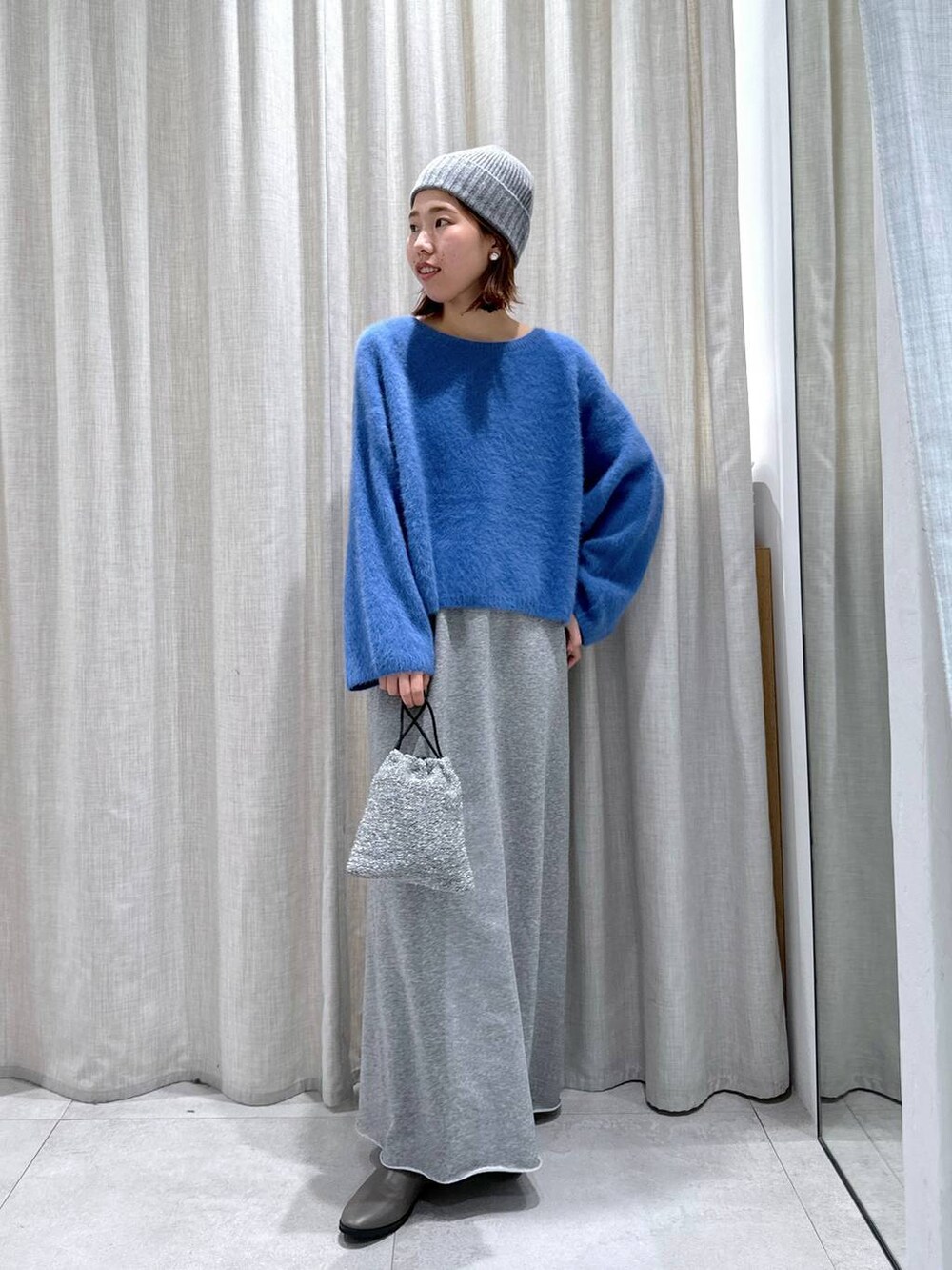 ブルー系のデニムジャケット、ブルー系のニット/セーター、シルバー系のショルダーバッグを着用したレディースの秋コーディネートの6枚目の写真