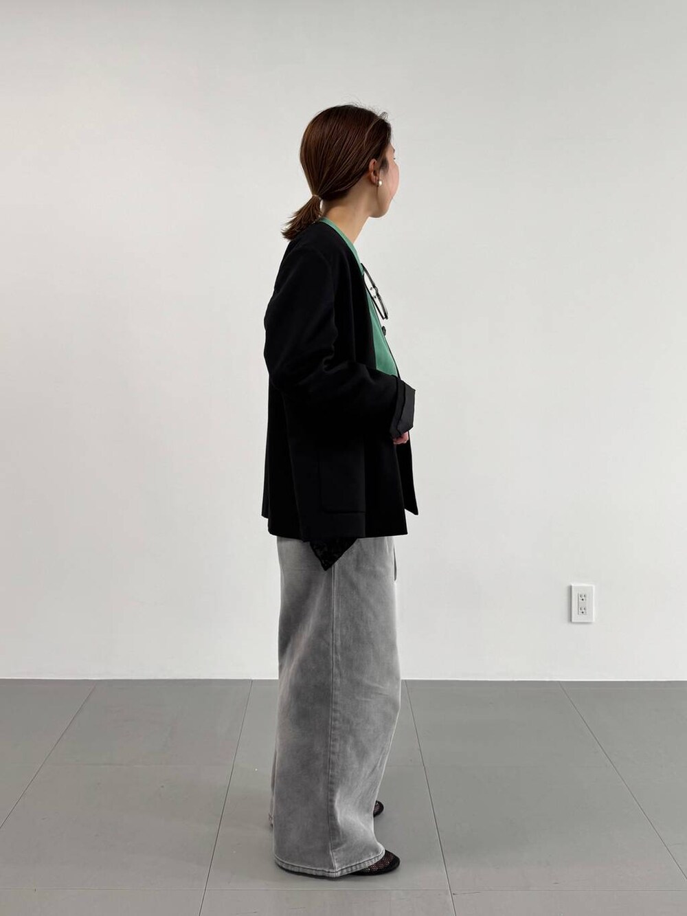 グレー系のデニムパンツ、ブラック系のパンプス、ブラック系のノーカラージャケットを着用したレディースの冬コーディネートの4枚目の写真