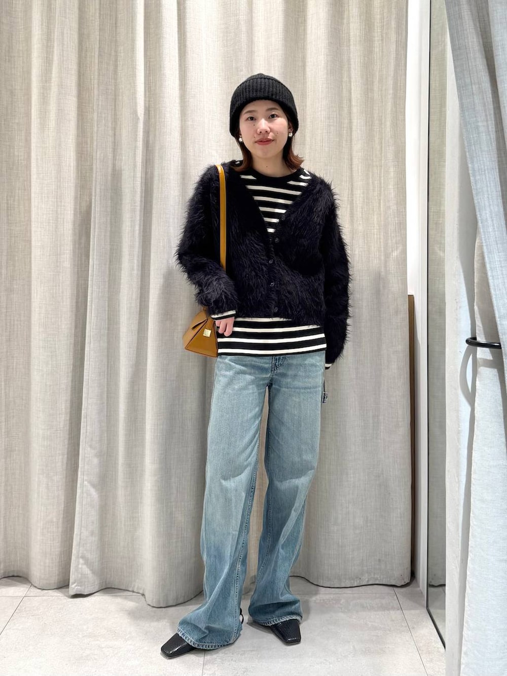 ブラック系のTシャツ/カットソー、ブルー系のカーディガン/ボレロ、ブルー系のデニムパンツを着用したレディースの冬コーディネートの2枚目の写真