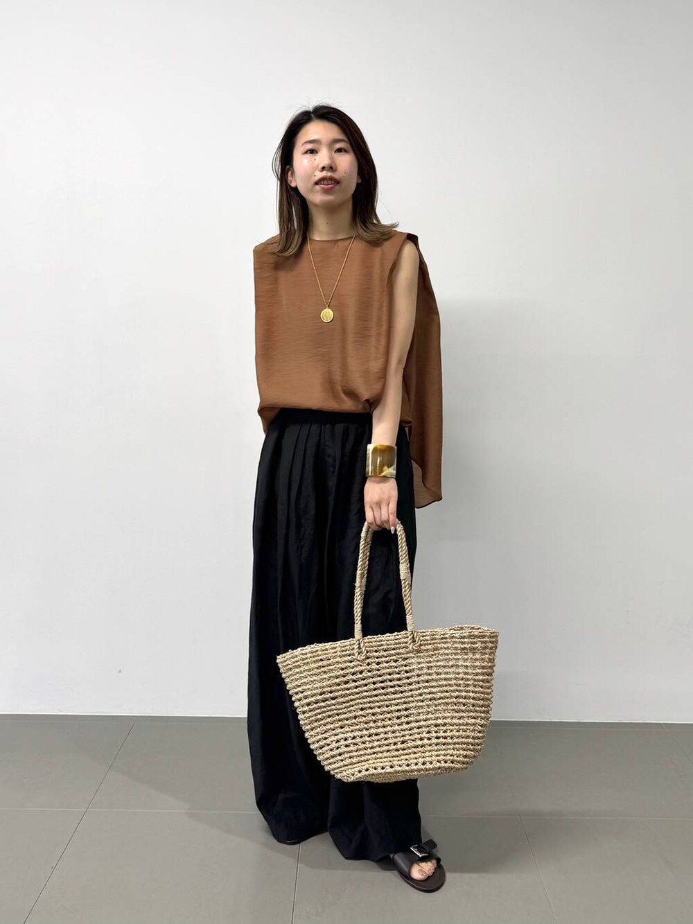 ベージュ系のかごバッグ、ブラウン系のシャツ/ブラウス、ブラック系のその他パンツを着用したレディースの夏コーディネートの5枚目の写真