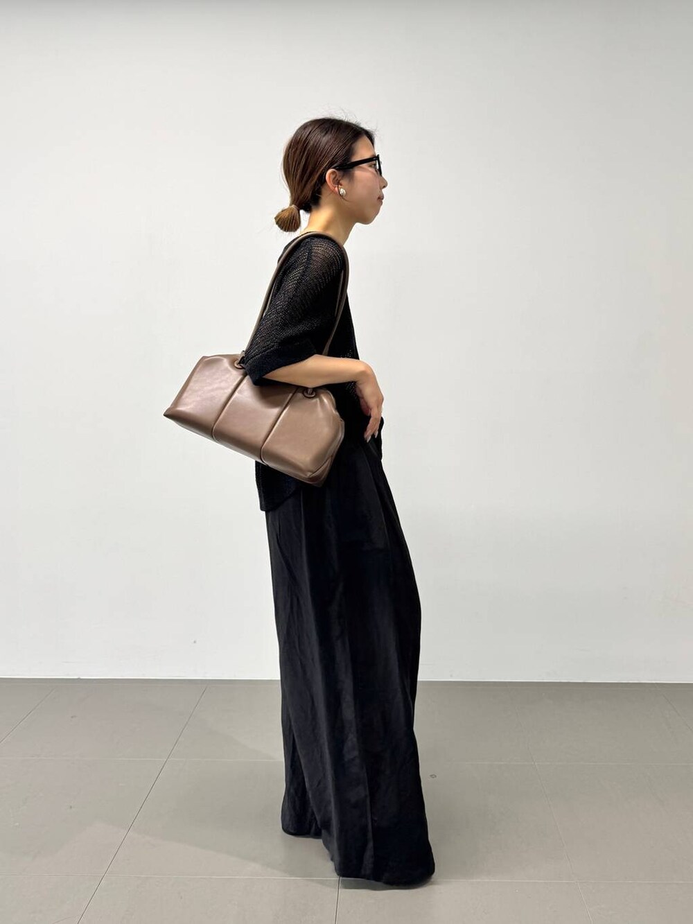 ブラック系のその他パンツ、ベージュ系のショルダーバッグ、ブラック系のTシャツ/カットソーを着用したレディースの夏コーディネートの6枚目の写真