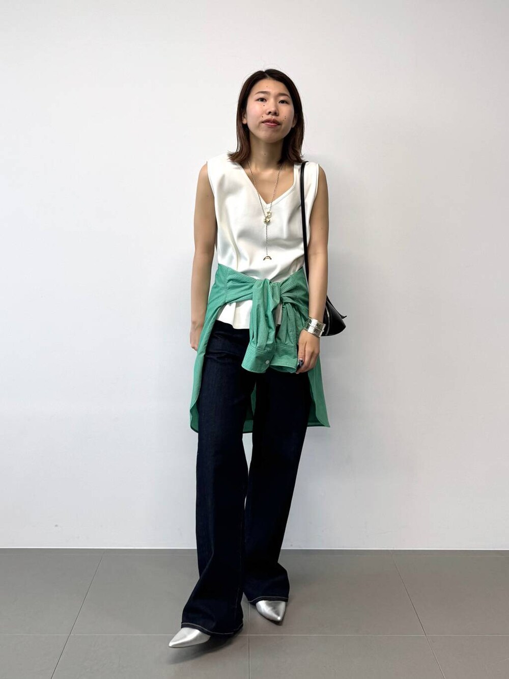 シルバー系のパンプス、グリーン系のシャツ/ブラウス、ホワイト系のTシャツ/カットソーを着用したレディースの夏コーディネートの4枚目の写真