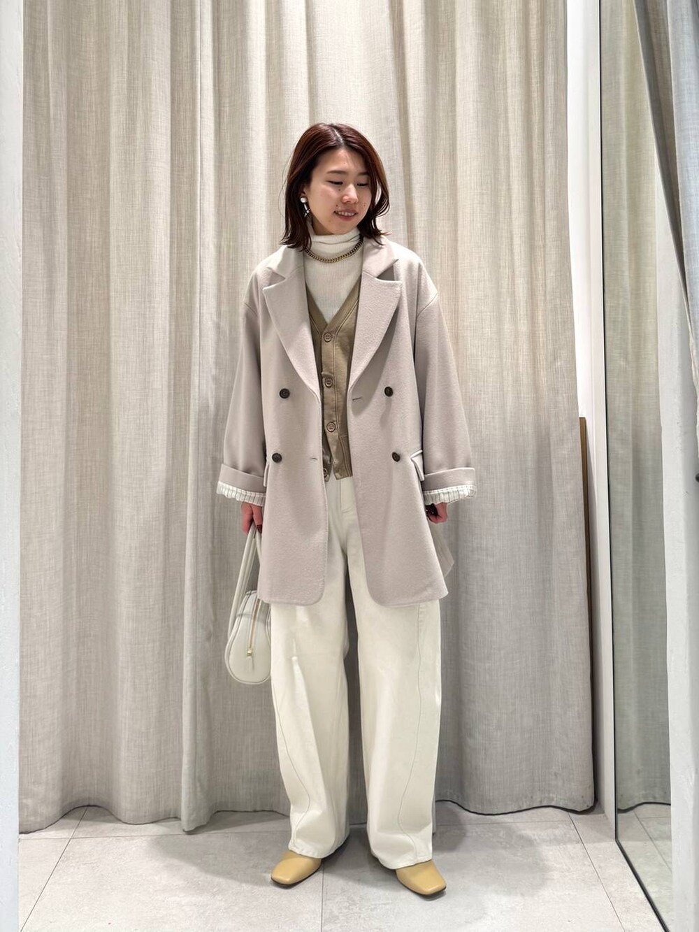 ホワイト系のニット/セーター、ベージュ系のテーラードジャケット、ベージュ系のカーディガン/ボレロを着用したレディースの冬コーディネートの6枚目の写真