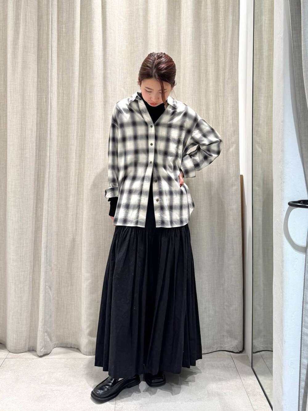 ブラック系のニット/セーター、ブラック系のシャツ/ブラウス、ブラック系のスカートを着用したレディースの冬コーディネートの5枚目の写真