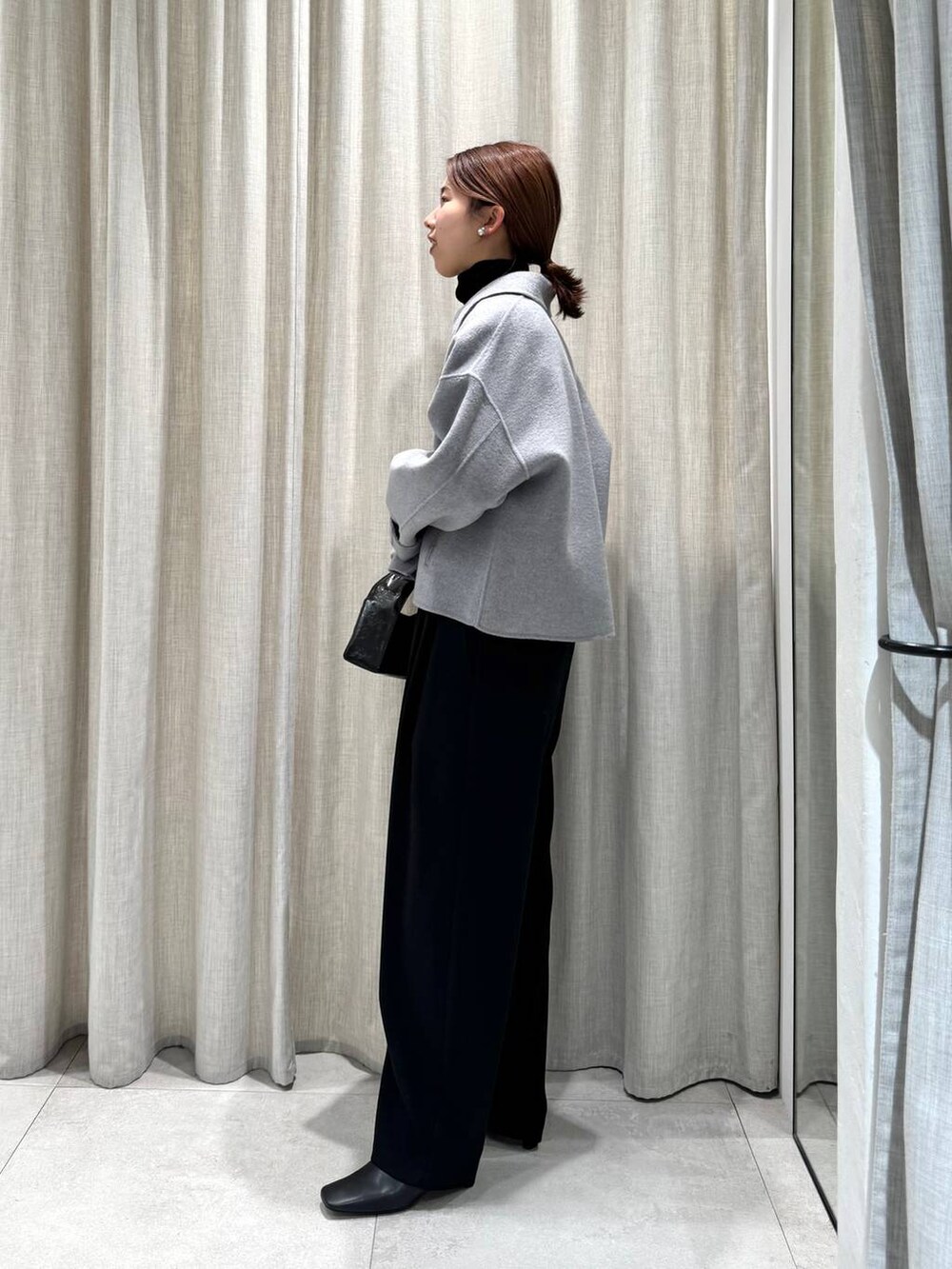 ブラック系のその他パンツ、ブラック系のニット/セーター、グレー系のその他アウターを着用したレディースの冬コーディネートの9枚目の写真