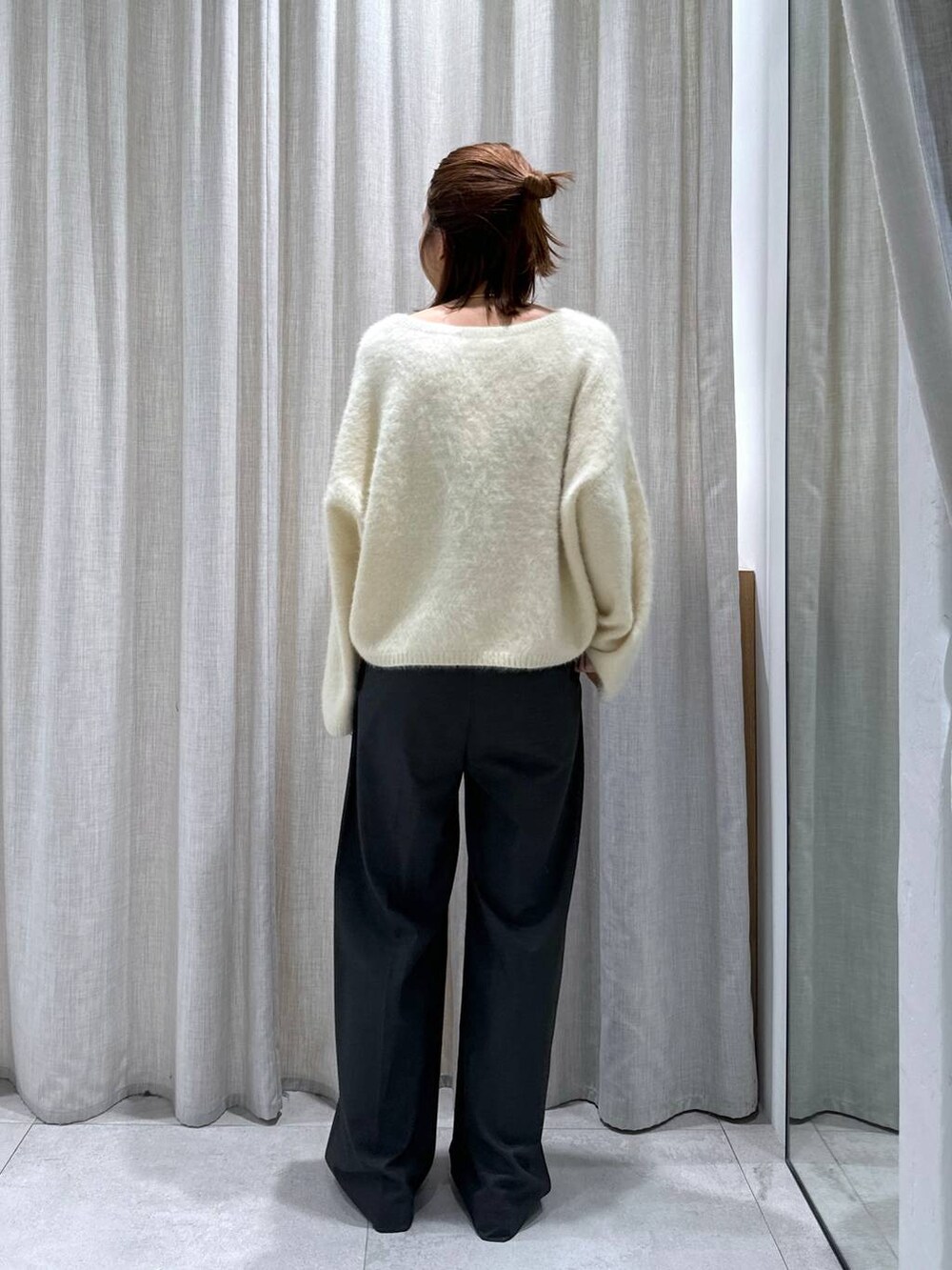 グレー系のスラックス、イエロー系のニット/セーターを着用したレディースの秋コーディネートの6枚目の写真