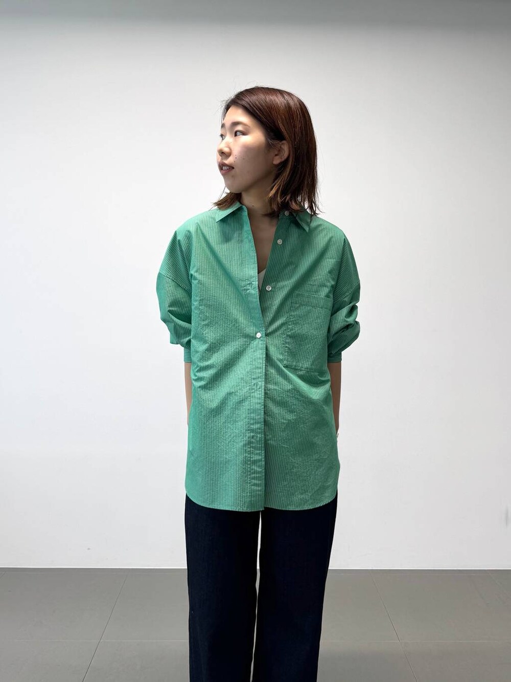 シルバー系のパンプス、グリーン系のシャツ/ブラウス、ホワイト系のTシャツ/カットソーを着用したレディースの夏コーディネートの7枚目の写真