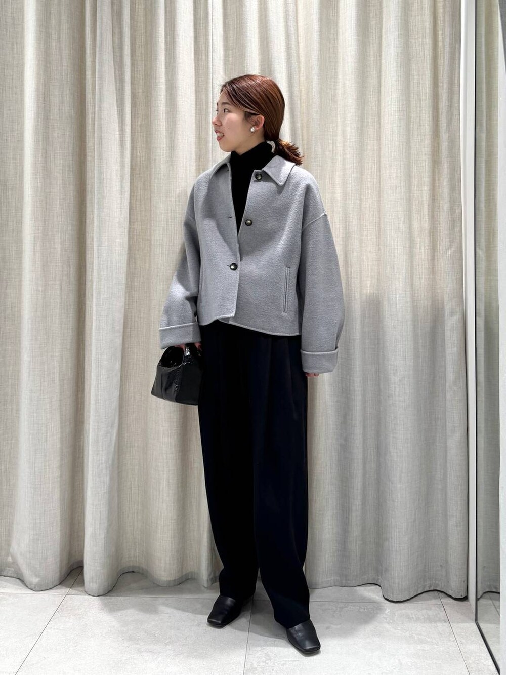 ブラック系のその他パンツ、ブラック系のニット/セーター、グレー系のその他アウターを着用したレディースの冬コーディネートの6枚目の写真