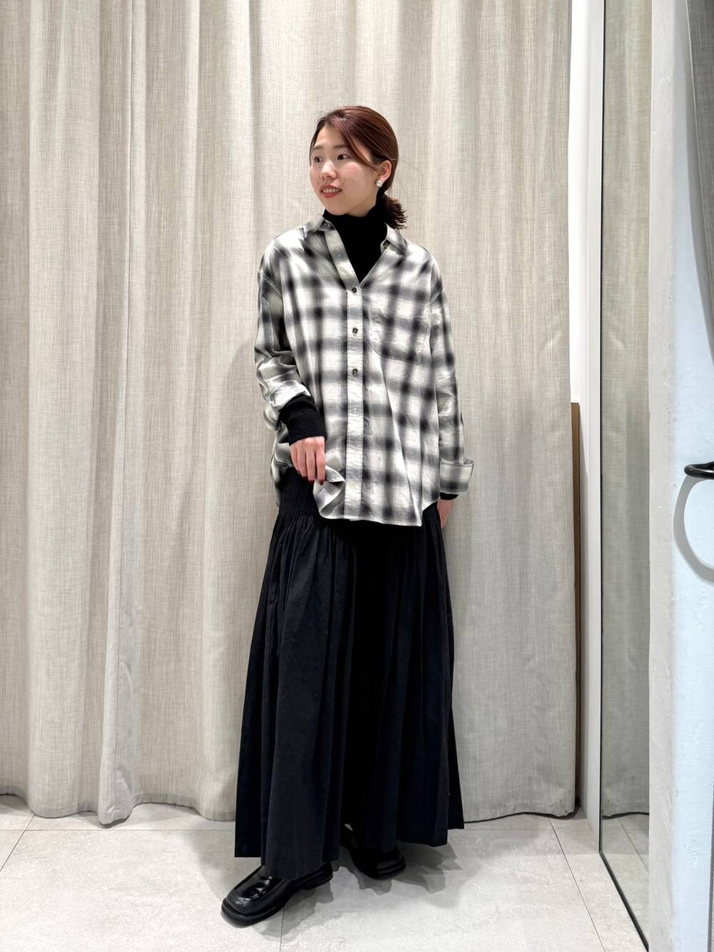 ブラック系のニット/セーター、ブラック系のシャツ/ブラウス、ブラック系のスカートを着用したレディースの冬コーディネートの4枚目の写真