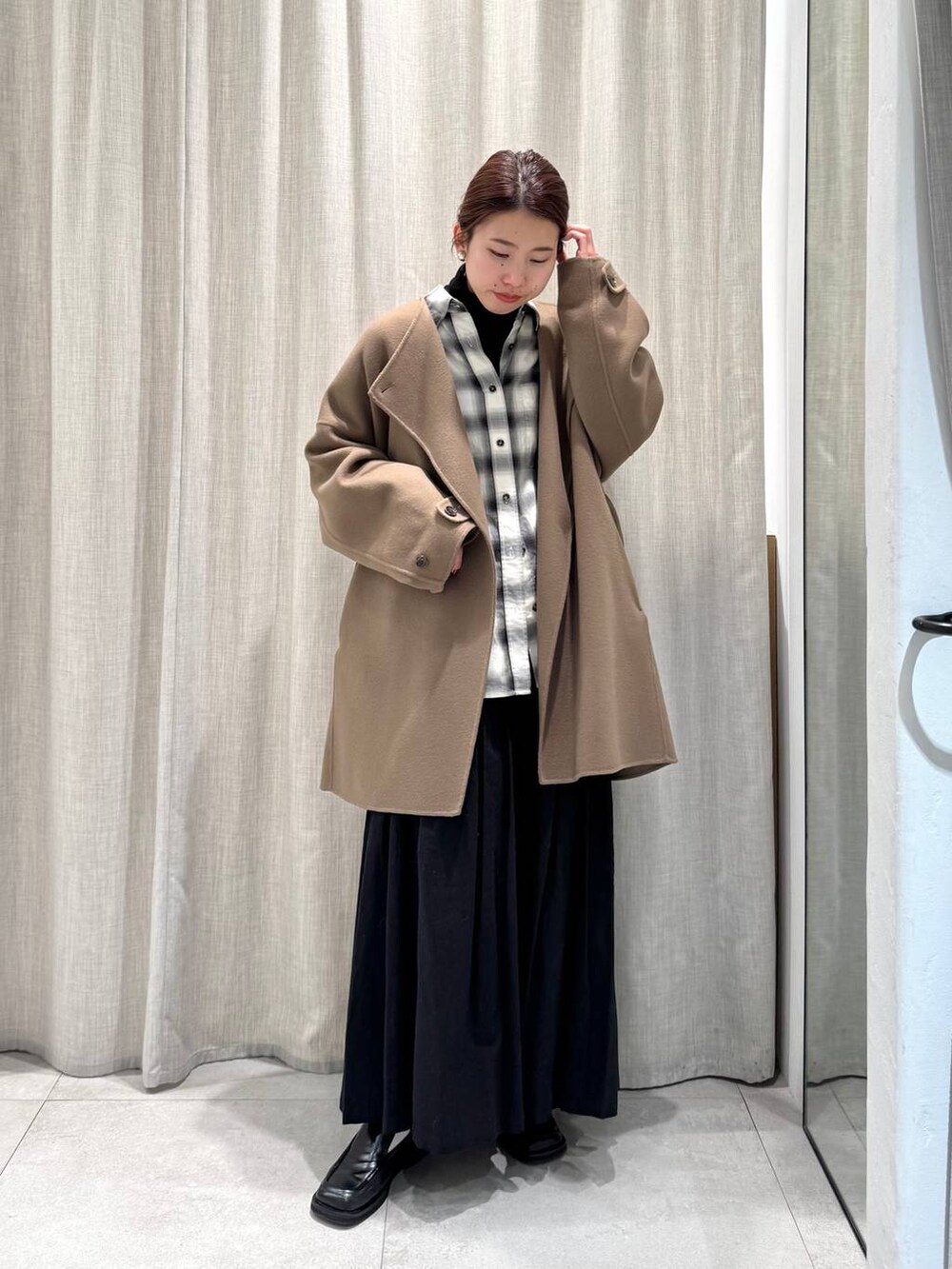 ブラック系のニット/セーター、ブラック系のシャツ/ブラウス、ブラック系のスカートを着用したレディースの冬コーディネートの8枚目の写真