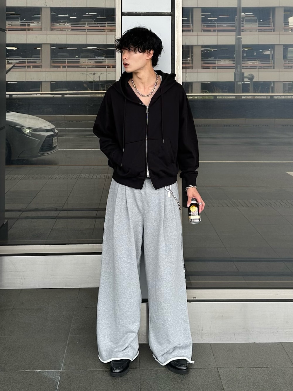 ブラック系のパーカー、グレー系のスウェットパンツ、ブラック系のローファーを着用したメンズの秋コーディネートの3枚目の写真
