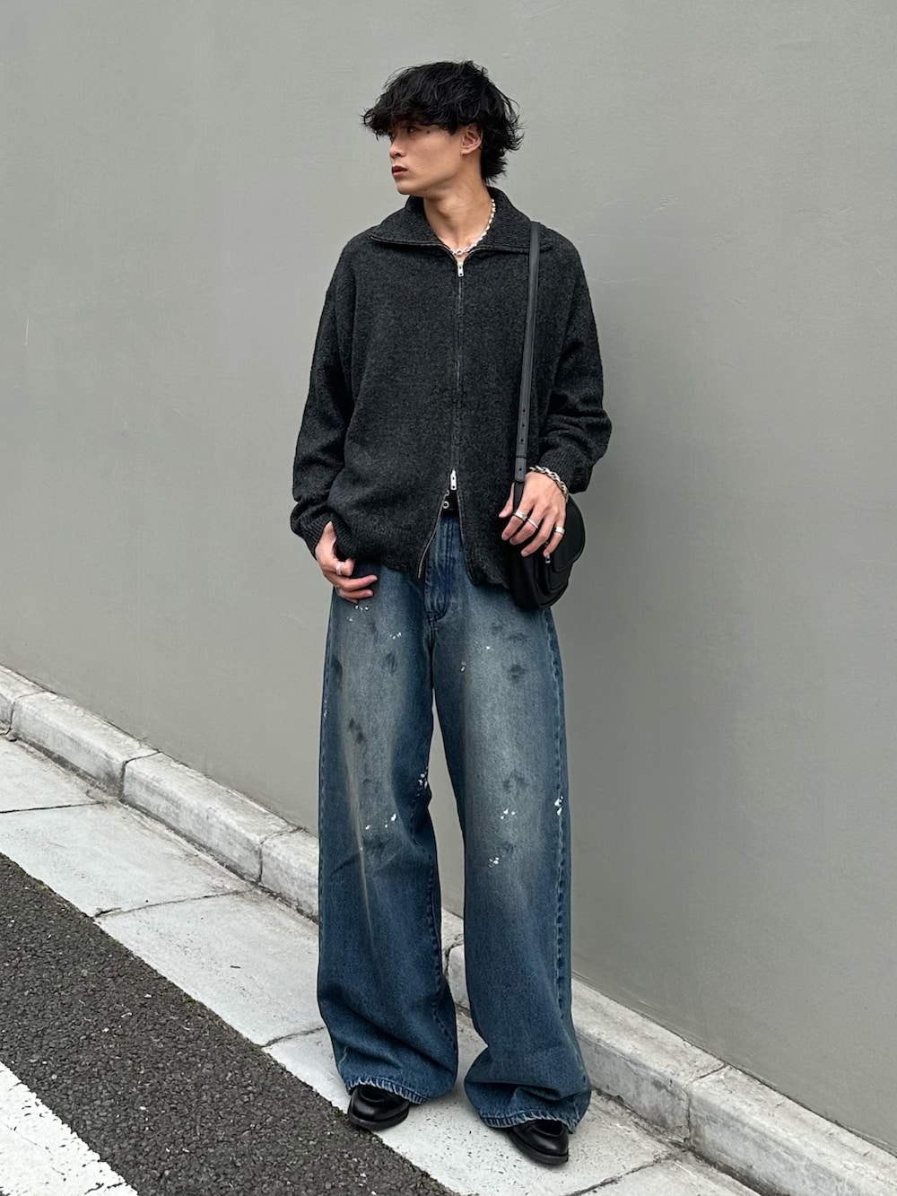 グレー系のニット/セーター、ブルー系のデニムパンツ、ブラック系のショルダーバッグを着用したメンズの秋コーディネートの3枚目の写真