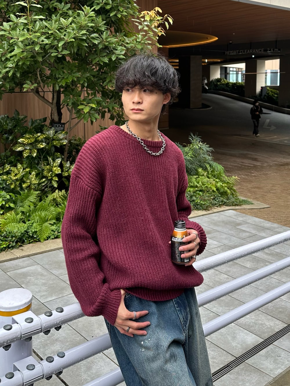 レッド系のニット/セーター、ブルー系のデニムパンツ、ブラック系のローファーを着用したメンズの秋コーディネートの3枚目の写真