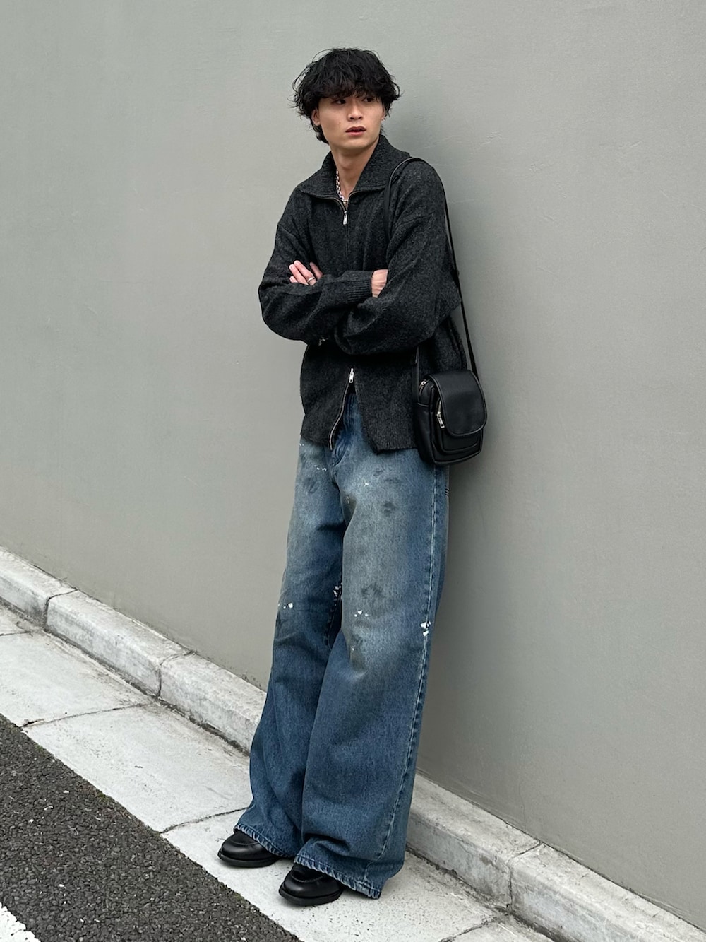 グレー系のニット/セーター、ブルー系のデニムパンツ、ブラック系のショルダーバッグを着用したメンズの秋コーディネートの2枚目の写真