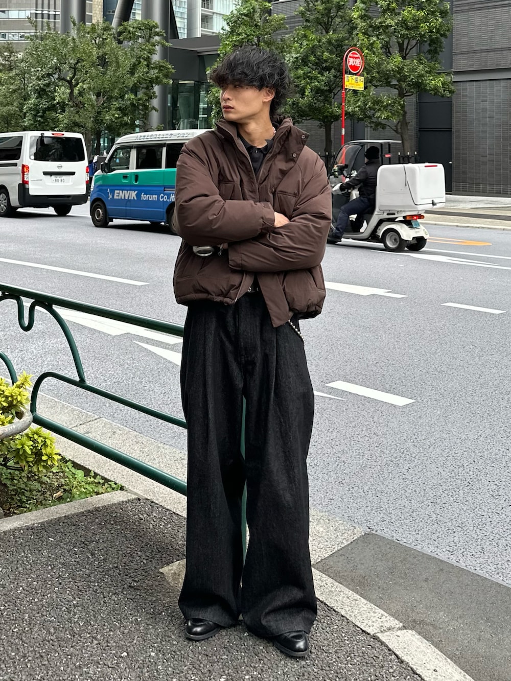 ブラック系のカーディガン/ボレロ、グレー系のダウンジャケット/コート、ブラック系のデニムパンツを着用したメンズの秋コーディネートの3枚目の写真