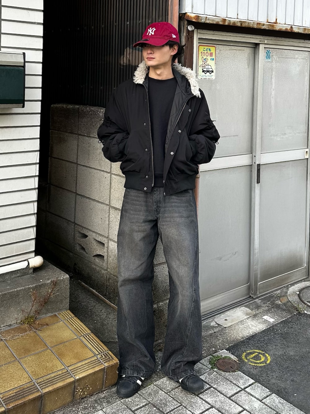 ブラック系のニット/セーター、ブルー系のデニムパンツ、ブラック系のスニーカーを着用したメンズの冬コーディネートの3枚目の写真