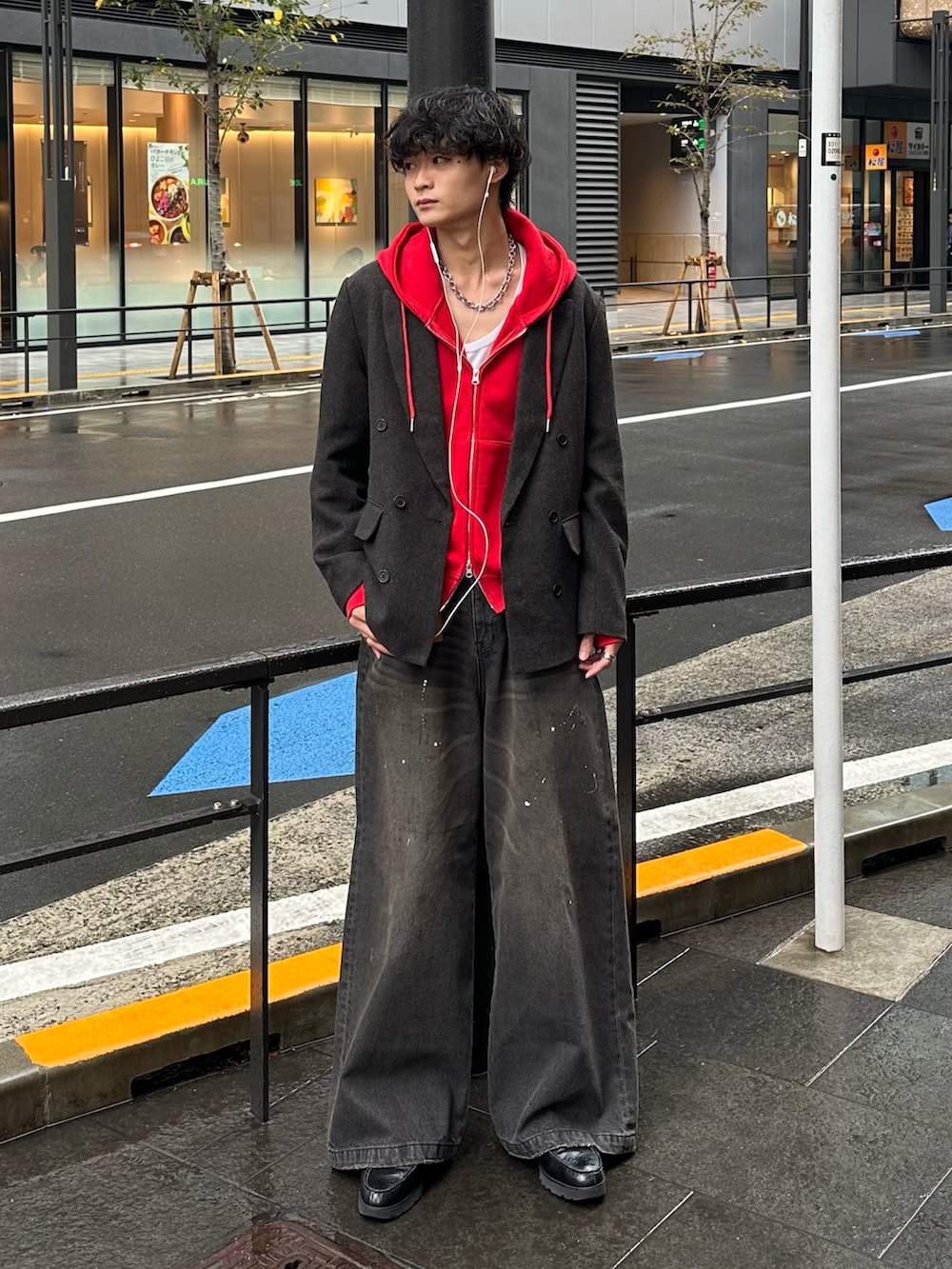 レッド系のパーカー、ブラック系のデニムパンツ、ブラック系のローファーを着用したメンズの秋コーディネートの3枚目の写真