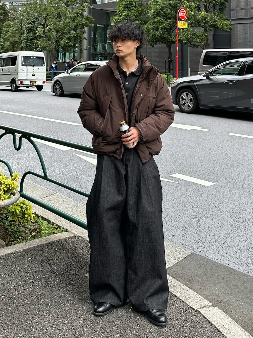 ブラック系のカーディガン/ボレロ、グレー系のダウンジャケット/コート、ブラック系のデニムパンツを着用したメンズの秋コーディネートの2枚目の写真