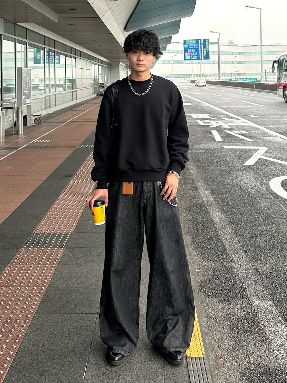 ブラック系のデニムパンツ、ブラック系のスウェット、ブラック系のローファーを着用したメンズの秋コーディネートの2枚目の写真