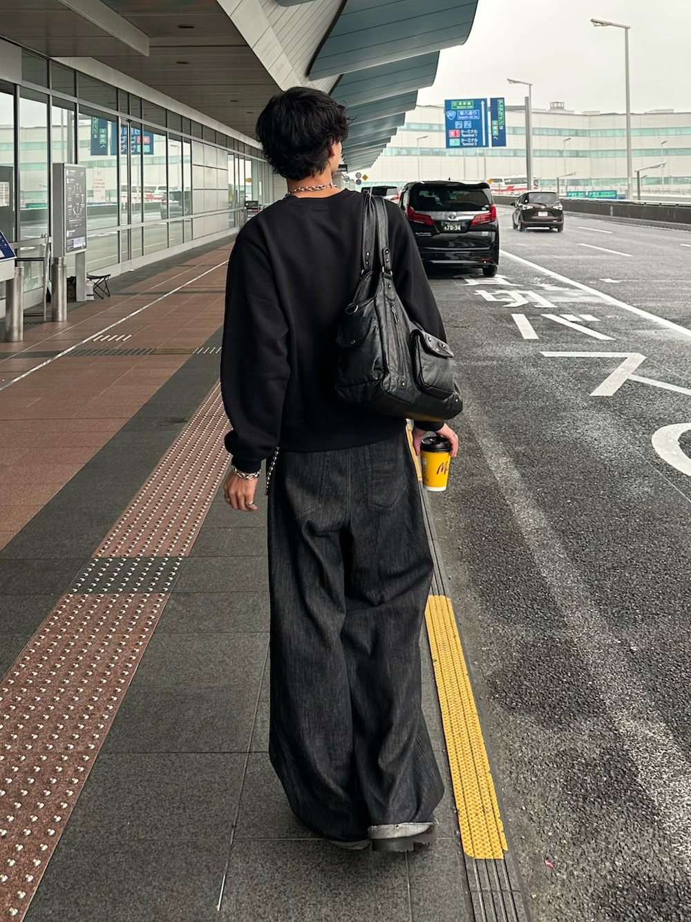 ブラック系のデニムパンツ、ブラック系のスウェット、ブラック系のローファーを着用したメンズの秋コーディネートの4枚目の写真