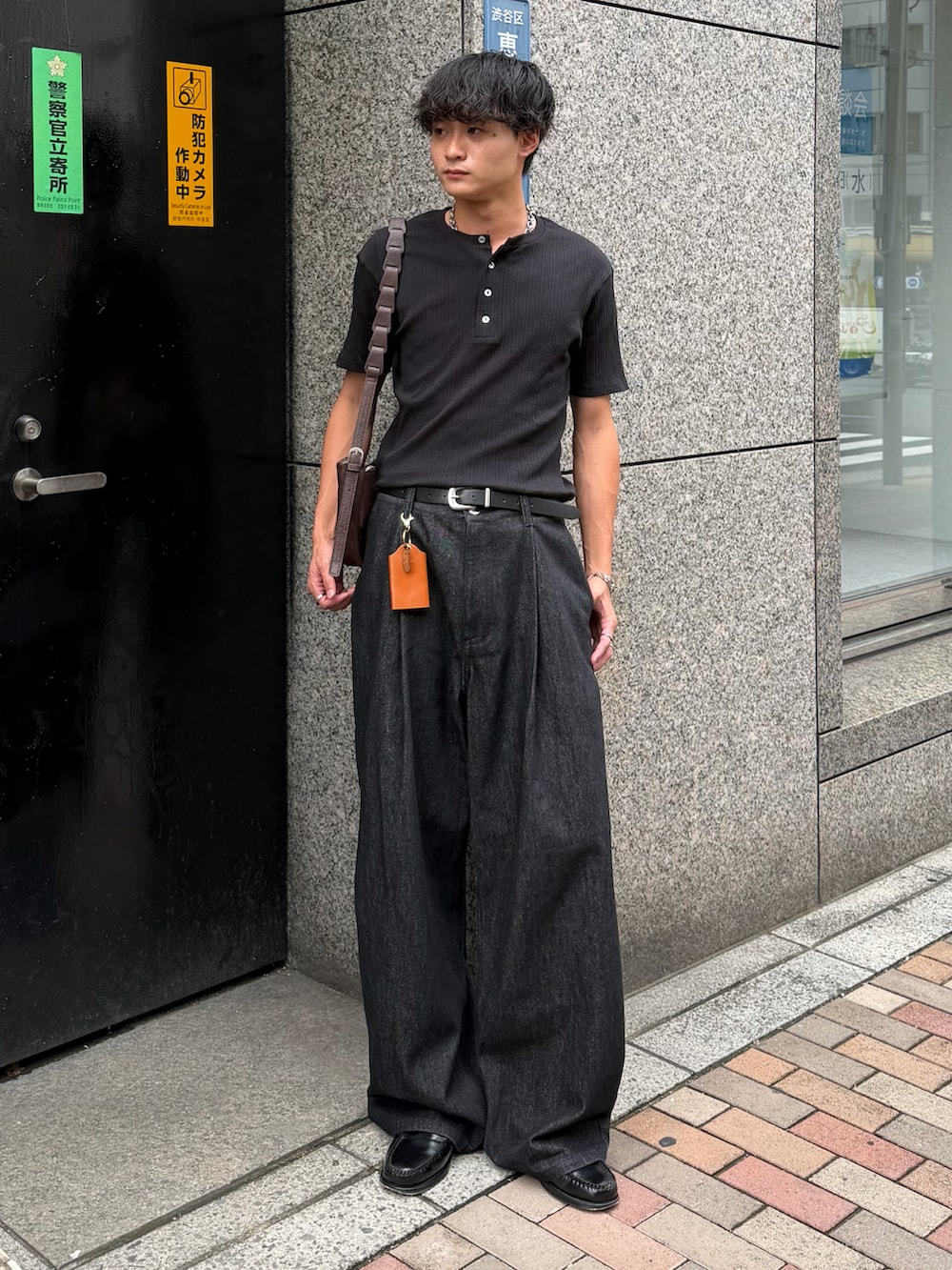 ブラック系のTシャツ/カットソー、ブラック系のデニムパンツ、ブラック系のローファーを着用したメンズの夏コーディネートの2枚目の写真