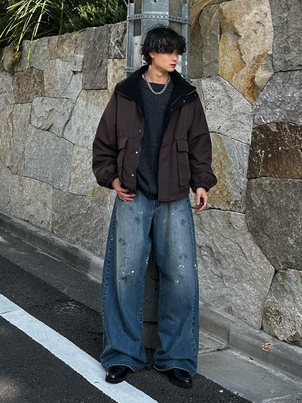 グレー系のニット/セーター、ブラック系のブルゾン、ブルー系のデニムパンツを着用したメンズの冬コーディネートの3枚目の写真