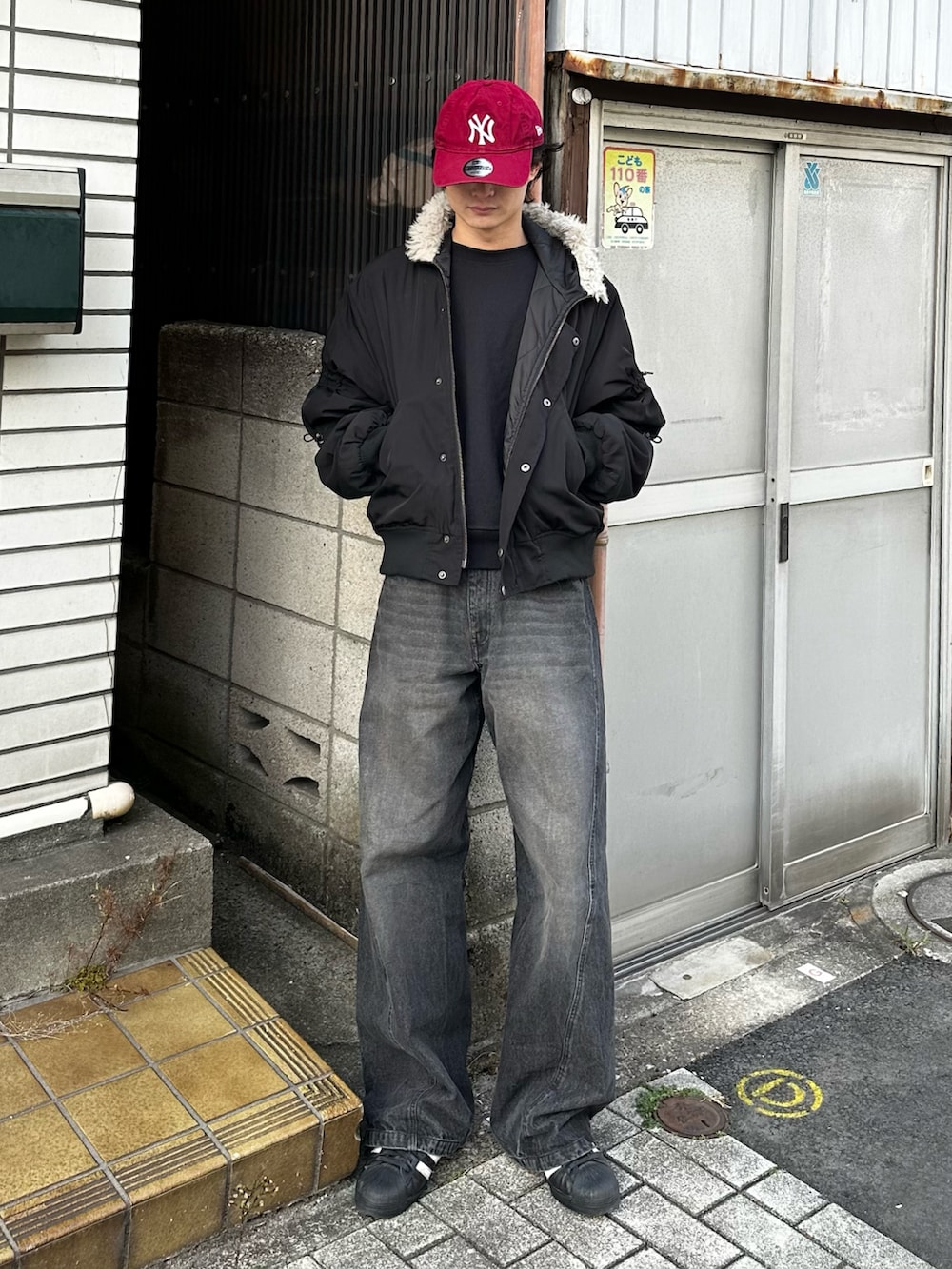 ブラック系のニット/セーター、ブルー系のデニムパンツ、ブラック系のスニーカーを着用したメンズの冬コーディネートの2枚目の写真