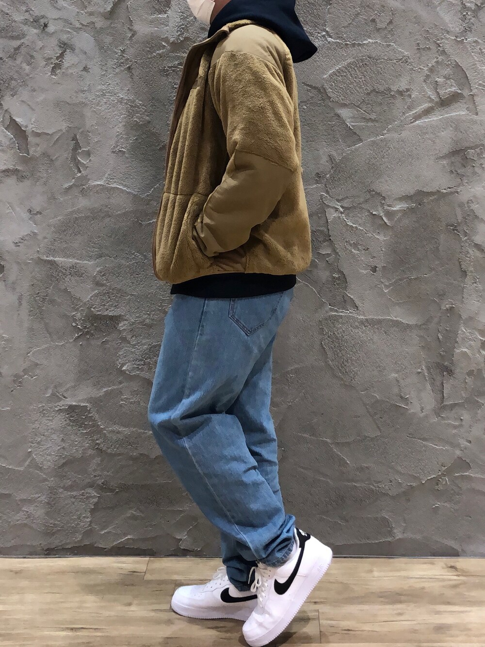 ブルー系のスウェット、ベージュ系のミリタリージャケット、ブルー系のデニムパンツを着用したメンズの冬コーディネートの2枚目の写真