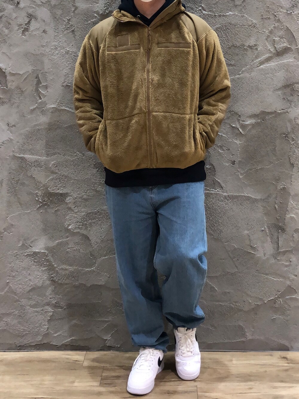 ブルー系のスウェット、ベージュ系のミリタリージャケット、ブルー系のデニムパンツを着用したメンズの冬コーディネートの3枚目の写真