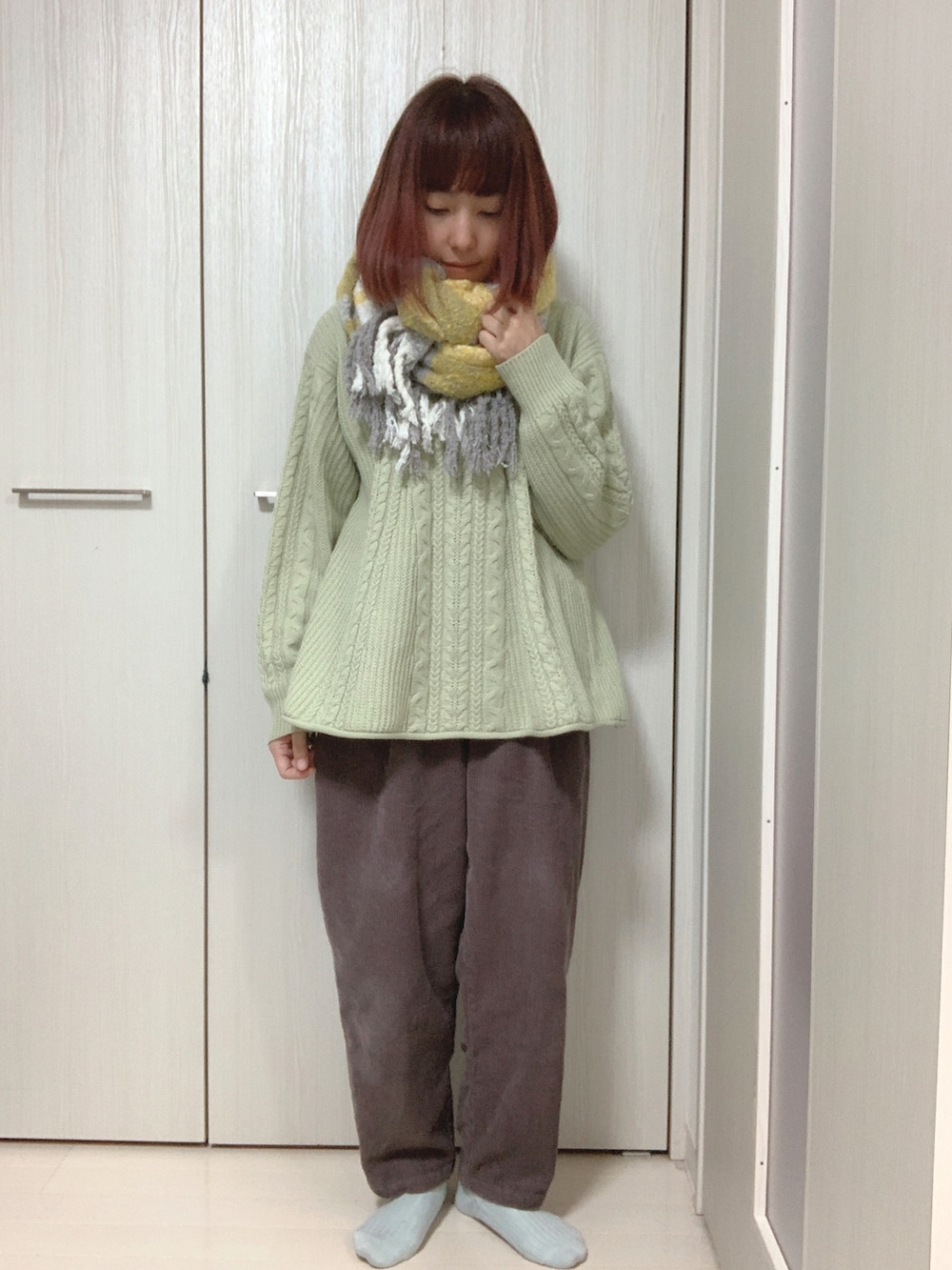 イエロー系のムートンコート、ブラウン系のその他パンツ、グリーン系のニット/セーターを着用したレディースの冬コーディネートの2枚目の写真