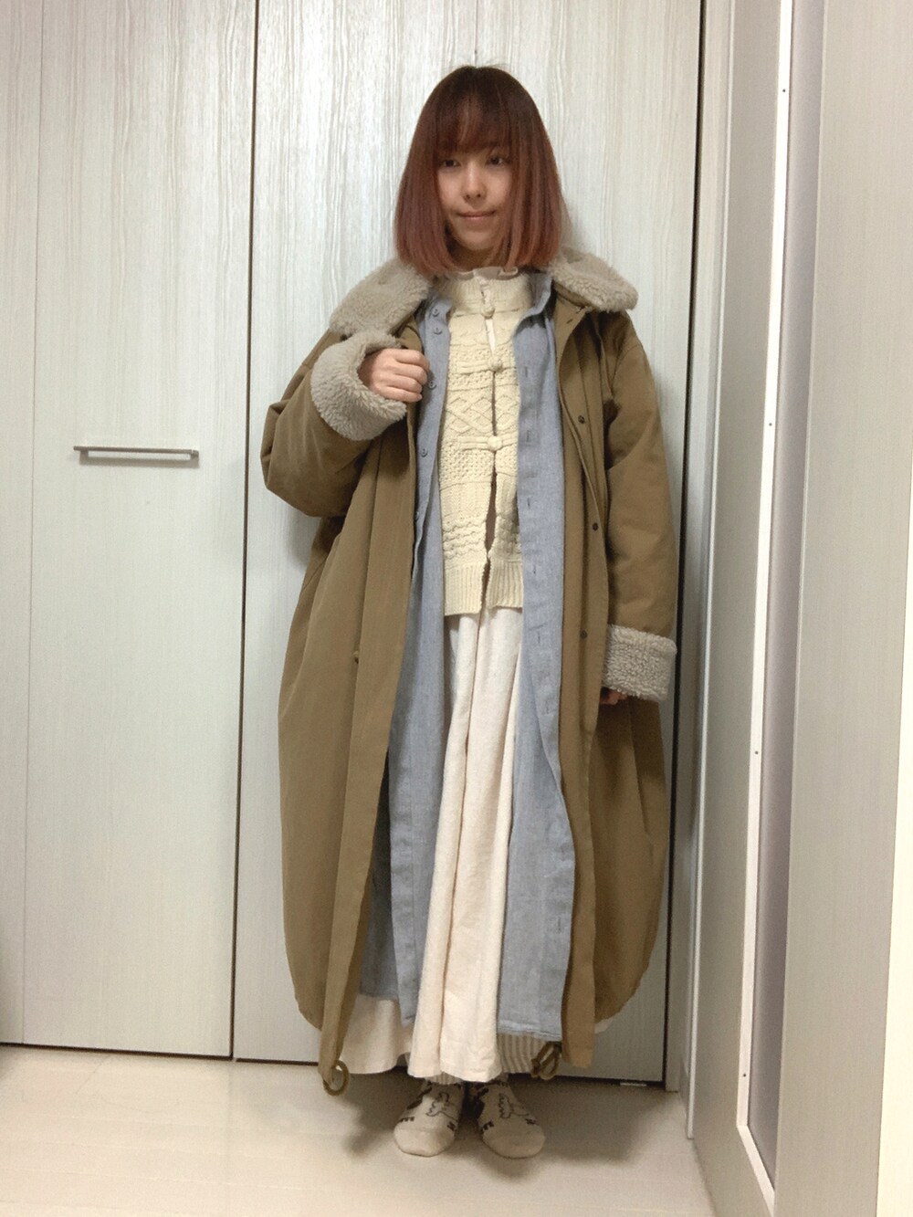 ホワイト系のカーディガン/ボレロ、ホワイト系のワンピース、グレー系のワンピース/ドレスを着用したレディースの冬コーディネートの2枚目の写真