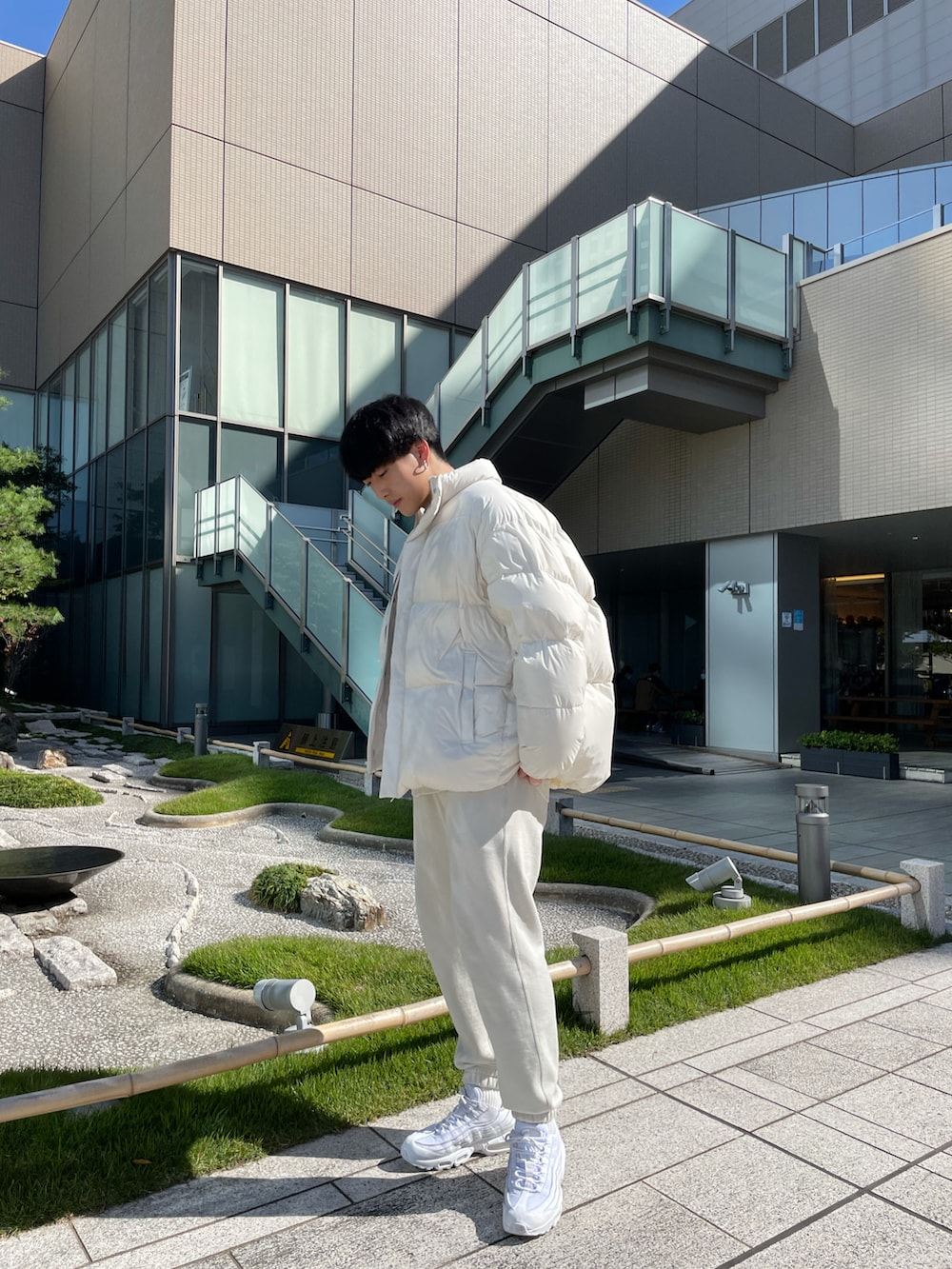 ホワイト系のスウェットパンツ、ホワイト系のスウェット、ホワイト系のダウンジャケット/コートを着用したメンズの秋コーディネートの2枚目の写真